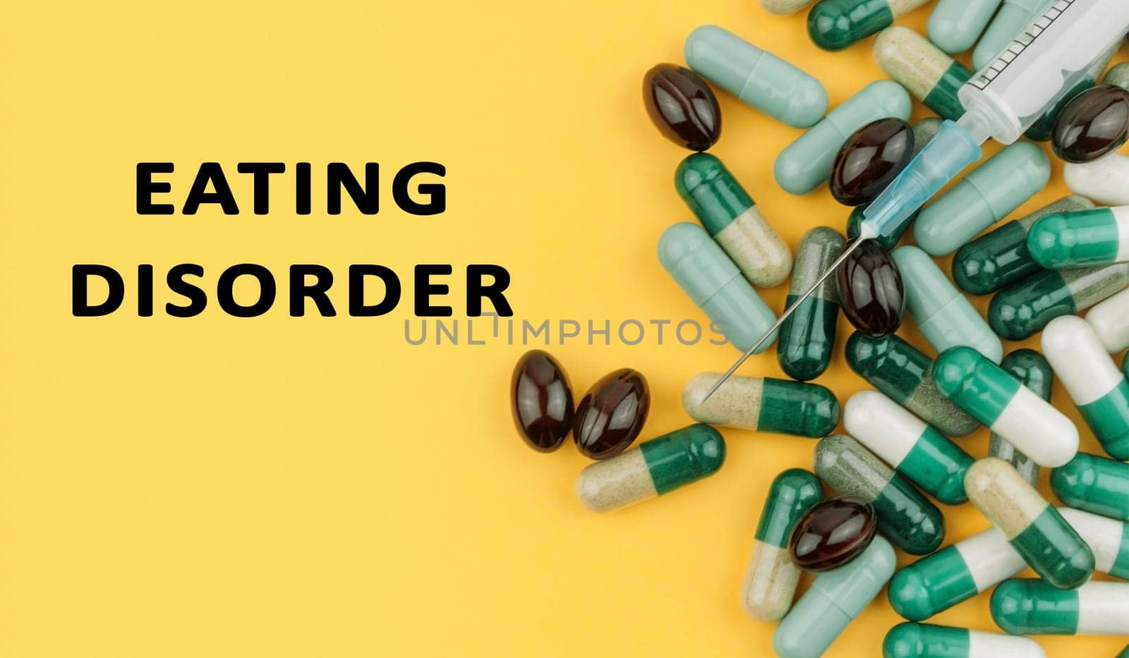 A bunch of pills with a syringe on top of them. The pills are green, white, and black. The image is titled Eating Disorder