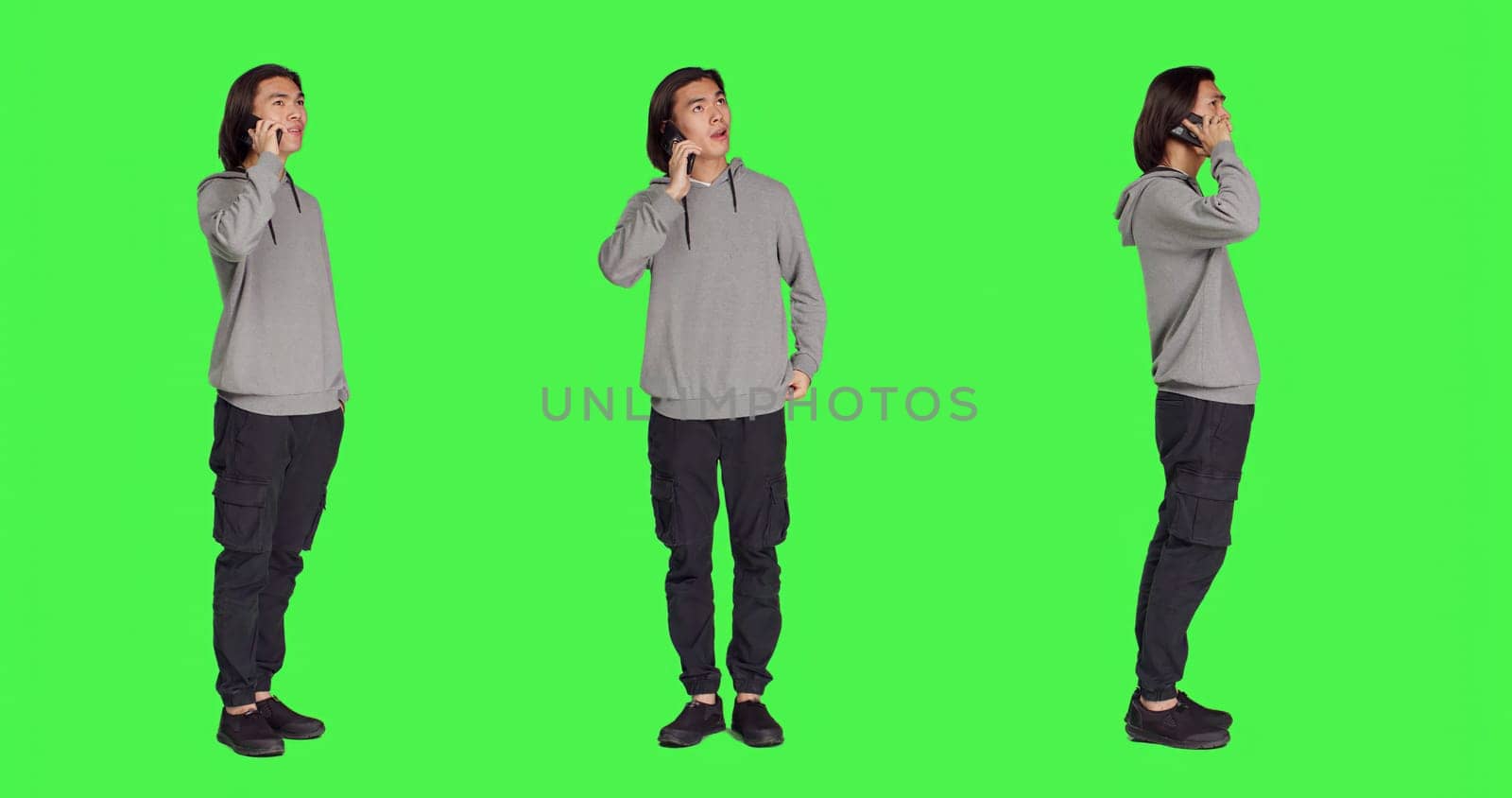 Modern guy talking on smartphone call over full body greenscreen, using telephone line to talk to his colleagues in studio. Young person answering call to have remote discussion.