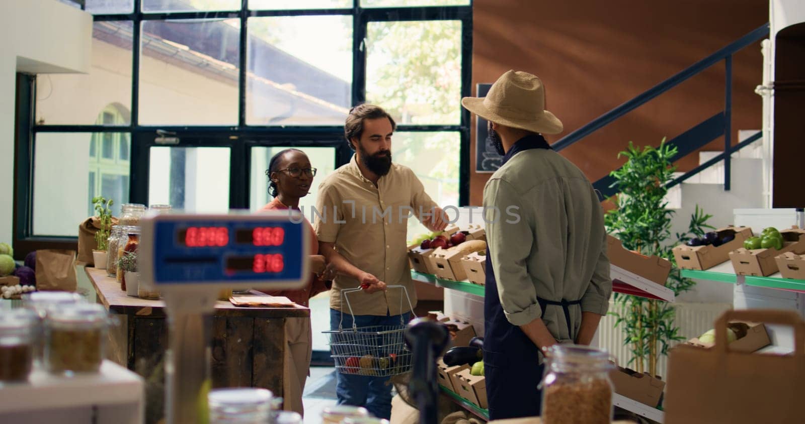 Couple asking vendor about fresh produce by DCStudio