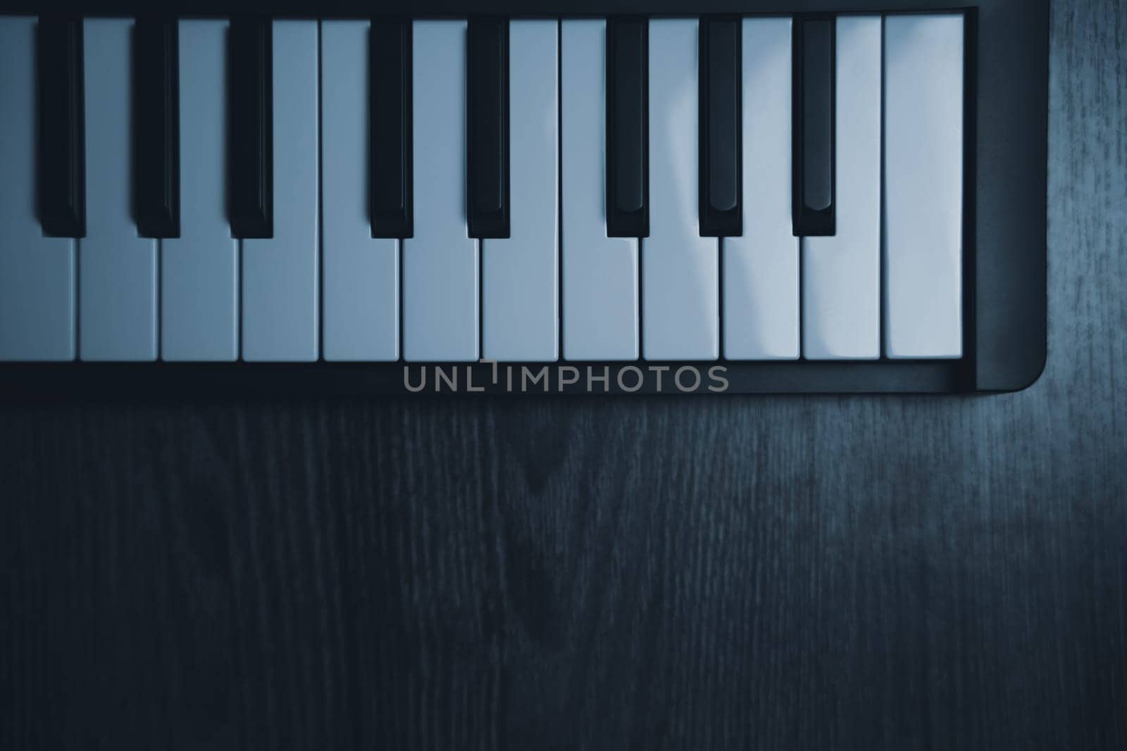 Black midi keyboard on a wooden table. Musical instrument. High quality photo