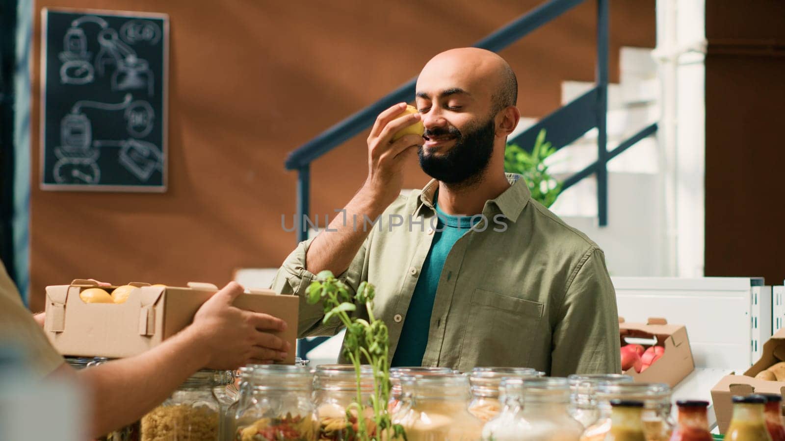 Client enjoying rich lemon aroma from local organic supermarket, grocery store vendor giving fruits to client to smell. Customer advertising sustainable lifestyle and vegan nutrition.