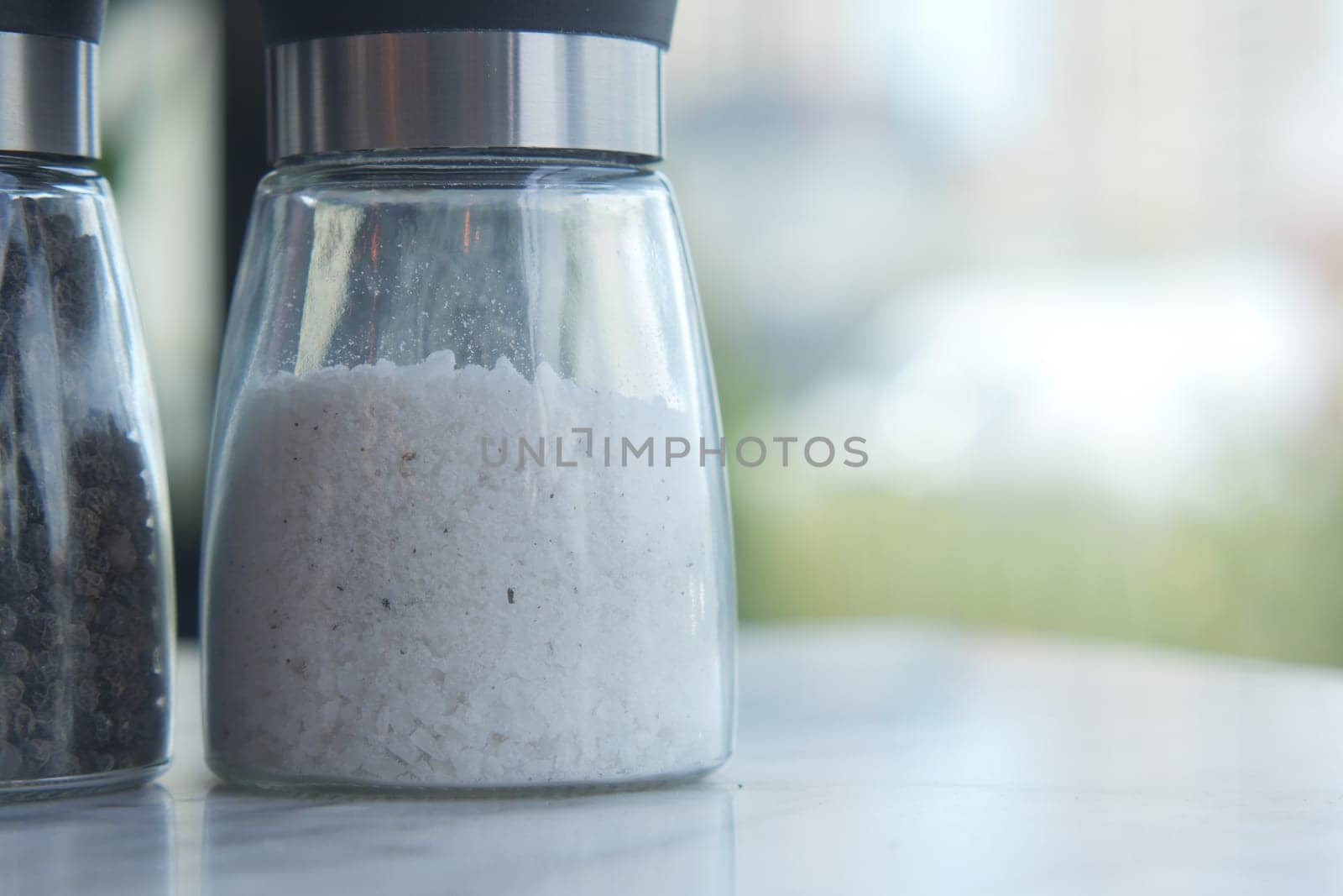 salt in a transparent jar on a table .