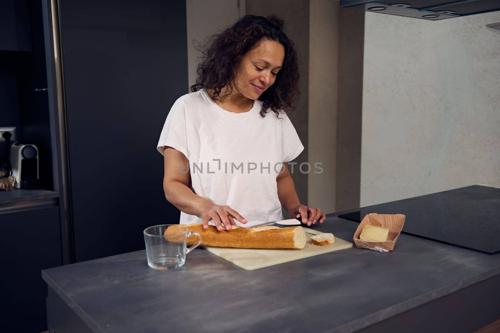 Woman cutting bread , preparing healthy sandwiches for breakfast in the home kitchen in the morning