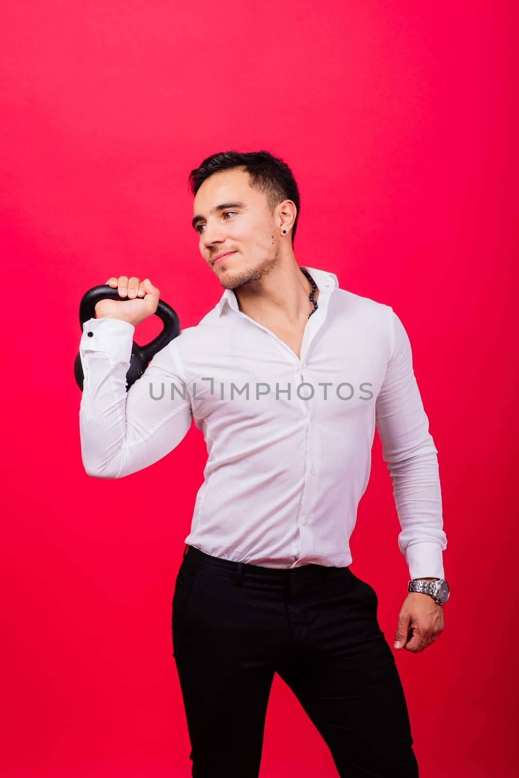 Attractive businessman Exercising With Kettlebell In studio, red background by Zelenin