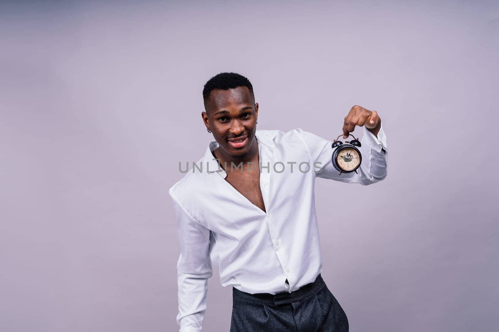 Time Management Concept. Shocked black man holding wall clock, running out of time. by Zelenin