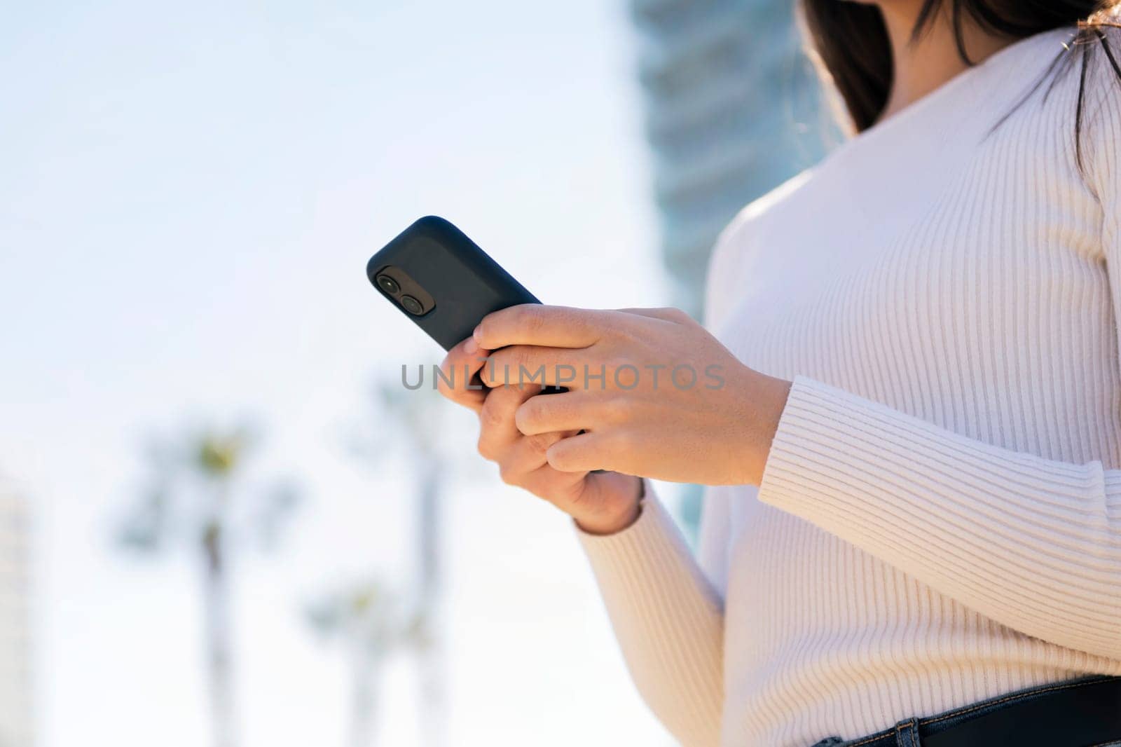 hands of an unrecognizable caucasian woman using mobile phone outdoors, concept of technology of communication and modern lifestyle, copy space for text