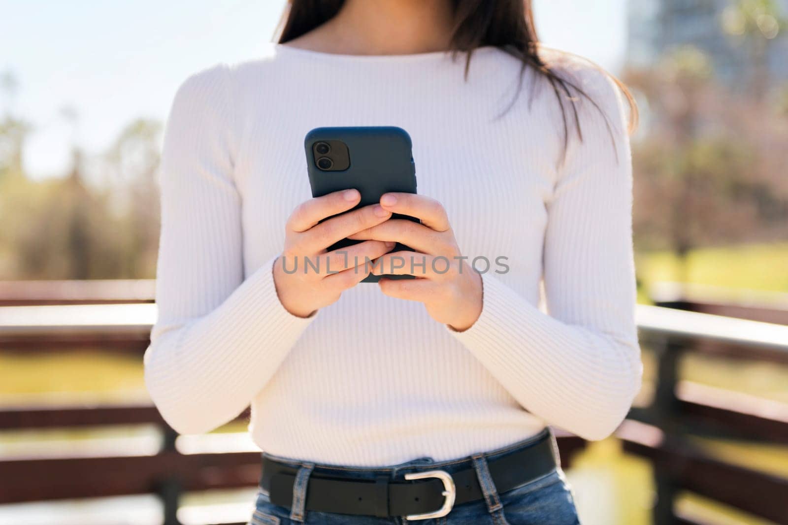 unrecognizable woman using mobile phone outdoors, concept of technology of communication and modern lifestyle