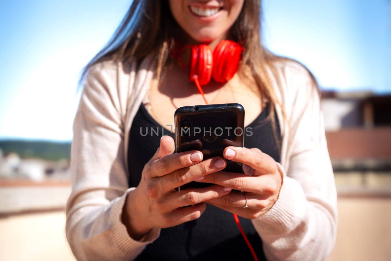 Satisfied with the results, the businesswoman walking on the street outside the office building, a young boss holds a phone in her hands, writes messages and reads news online, using an app.