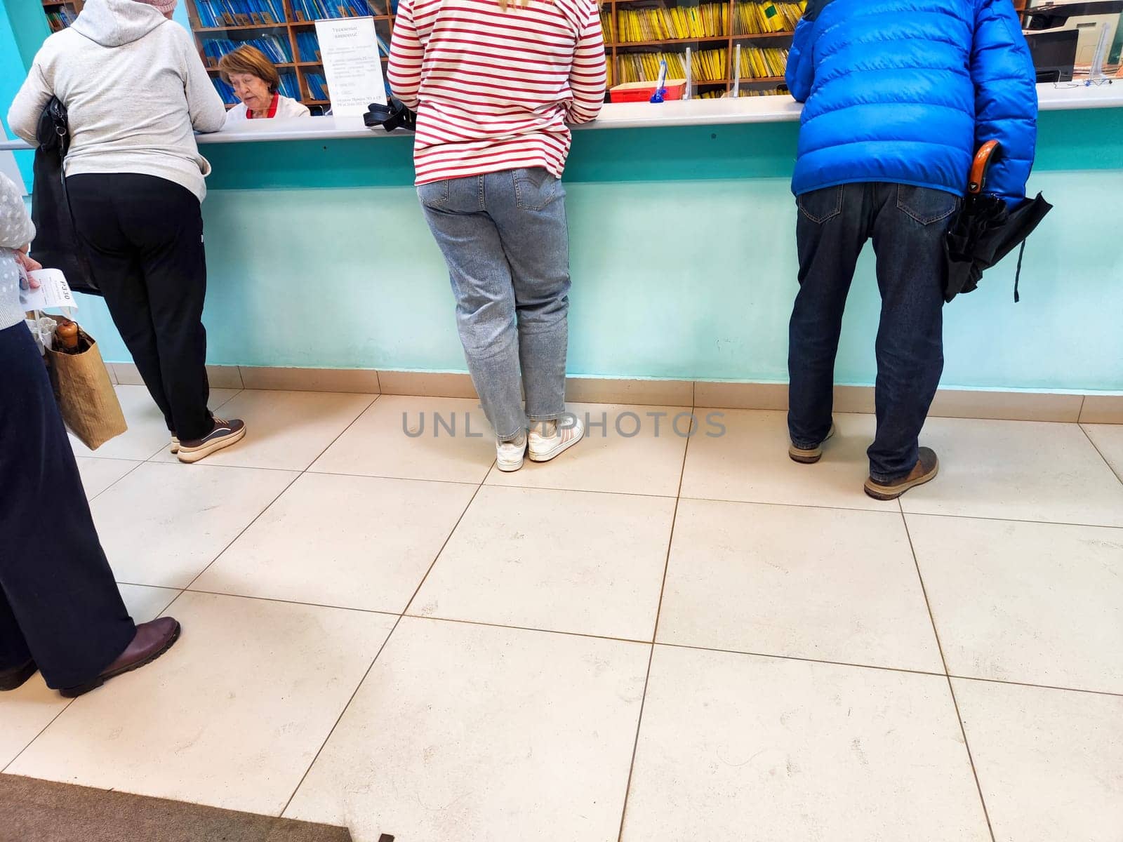 Kirov, Russia - May 06, 2024: Counter During Daytime. Individuals line up at a counter, possibly at a bank or hospital, awaiting service