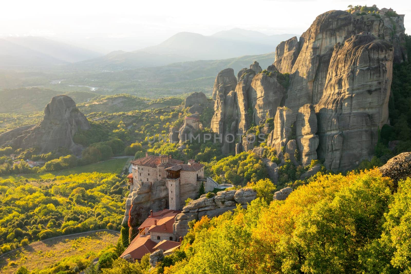 Greece. Evening in the green valley of Meteora. Picturesque rocks and a monastery on the cliff
