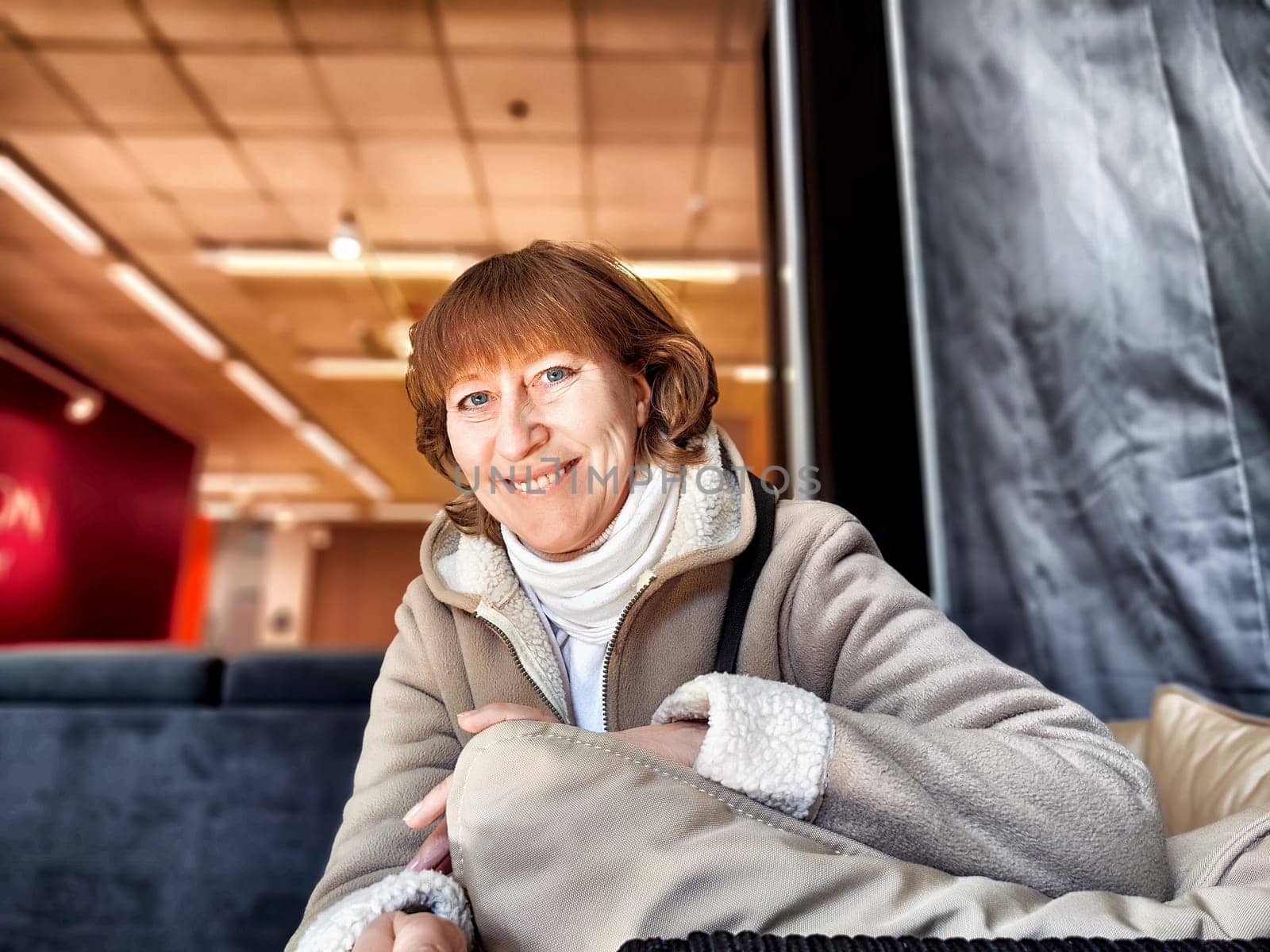 Middle-Aged Woman Captures Selfie While Shopping Indoors. Smiling adult shopper takes self-portrait during an indoor shopping trip