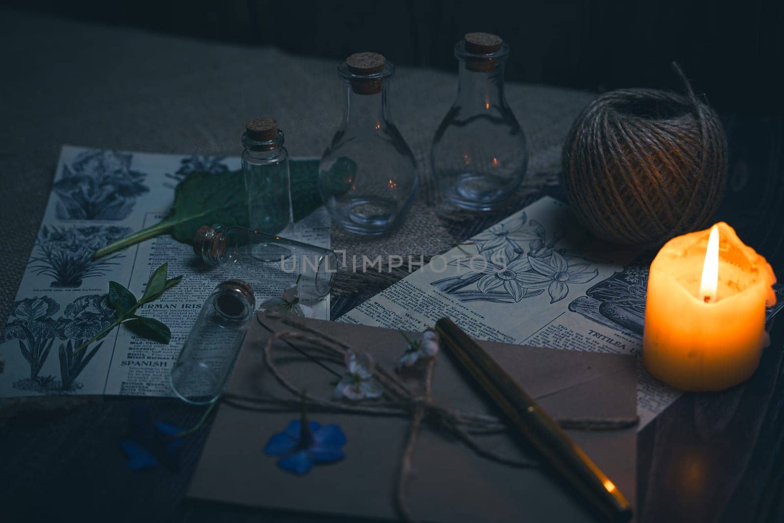 Mystical still life in vintage style with empty flasks, burning candles, letters and newspaper clippings. High quality photo