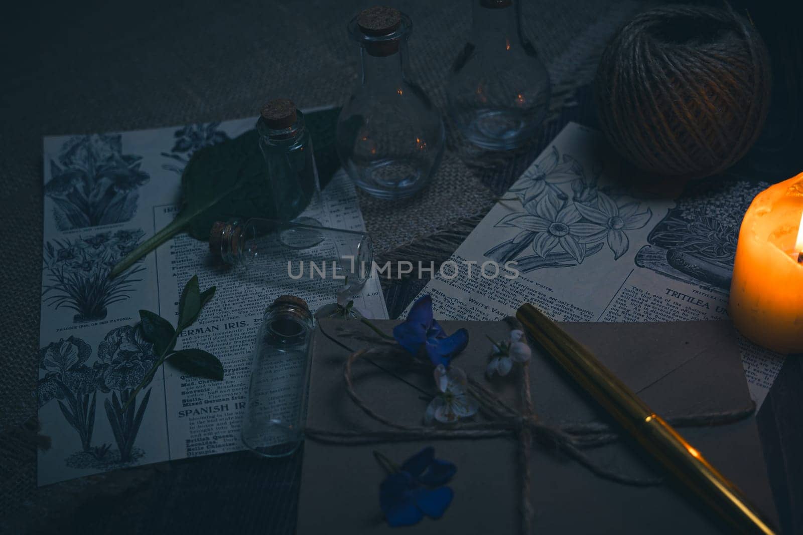 Mystical still life in vintage style with empty flasks, burning candles, letters and newspaper clippings. High quality photo