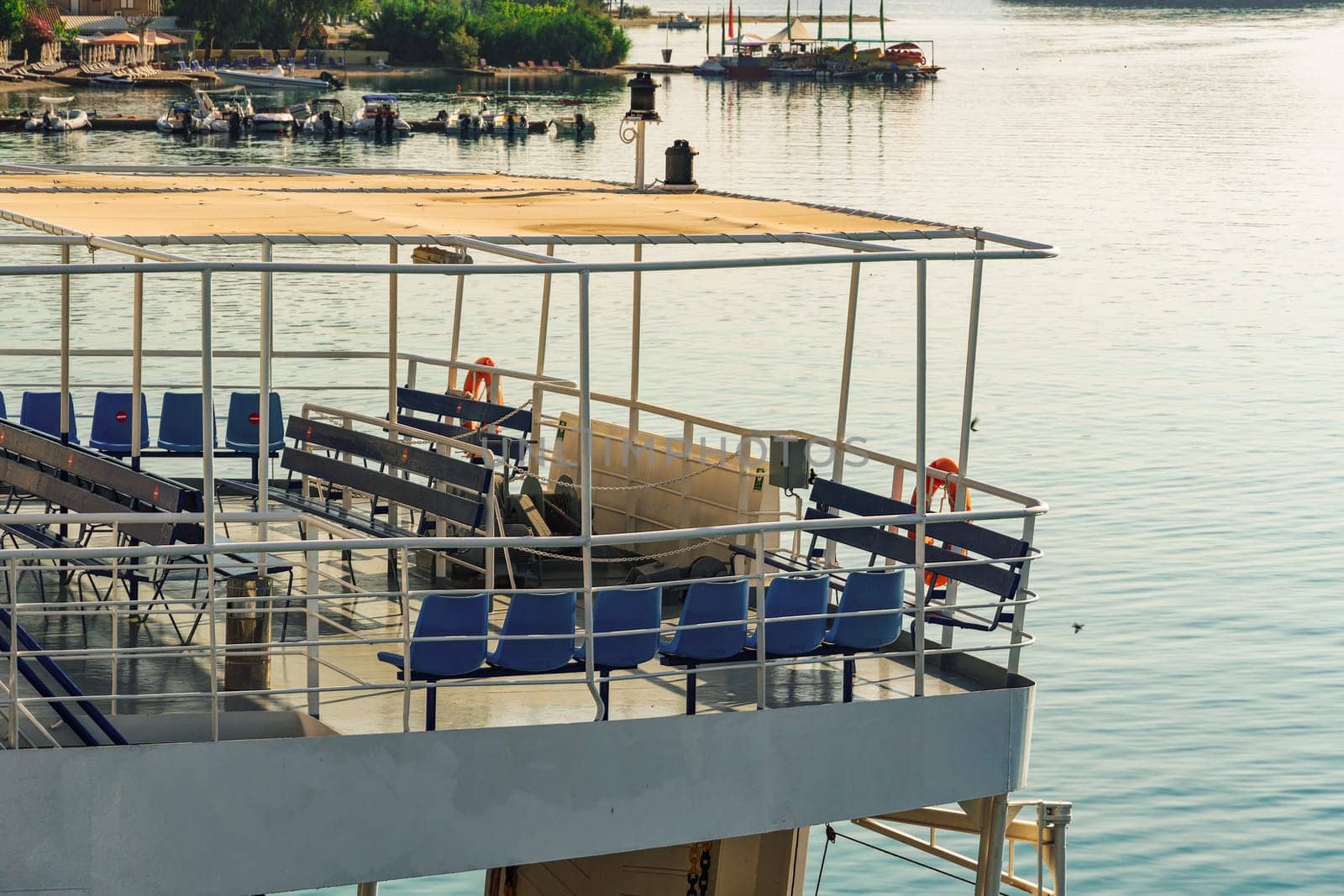 Rear view of car and passengers ferry with empty outdoor seating area, moored in Lefkada Ionian Island Greece.