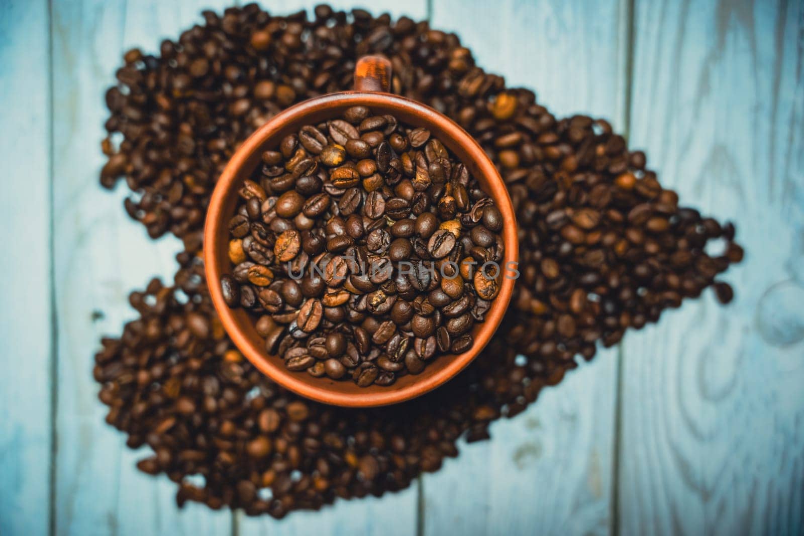 Coffee beans in a clay mug. A heart made of coffee beans. High quality photo