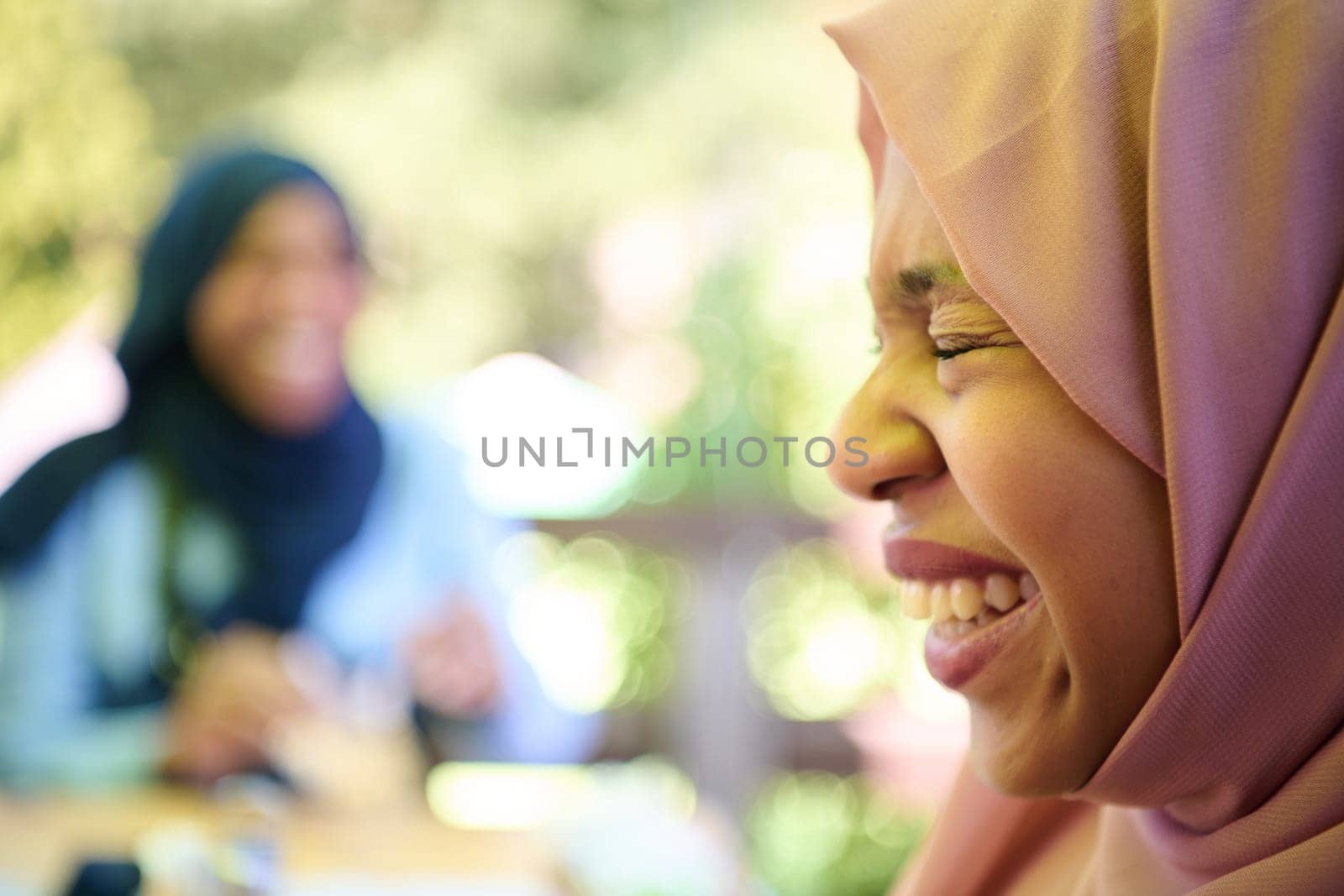 A Middle Eastern girl wearing a hijab, with a bright smile and a pink headscarf, captured in a close-up portrait exuding joy and positivity.