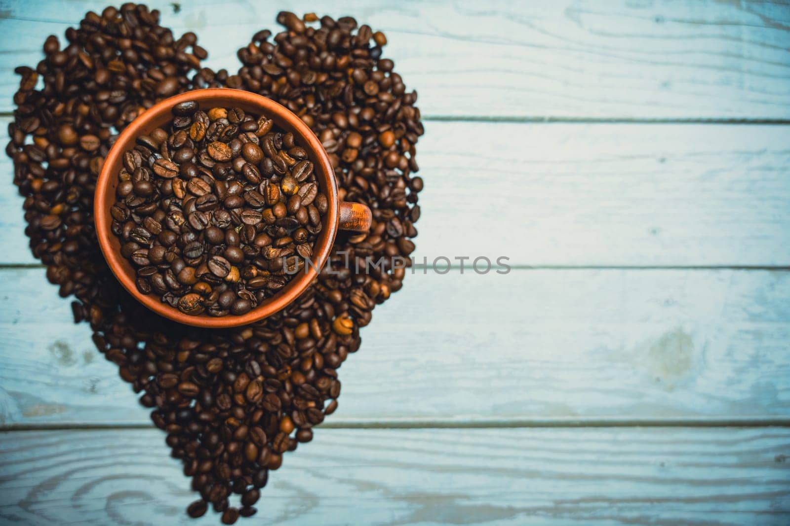 Coffee beans in a clay mug. A heart made of coffee beans. High quality photo