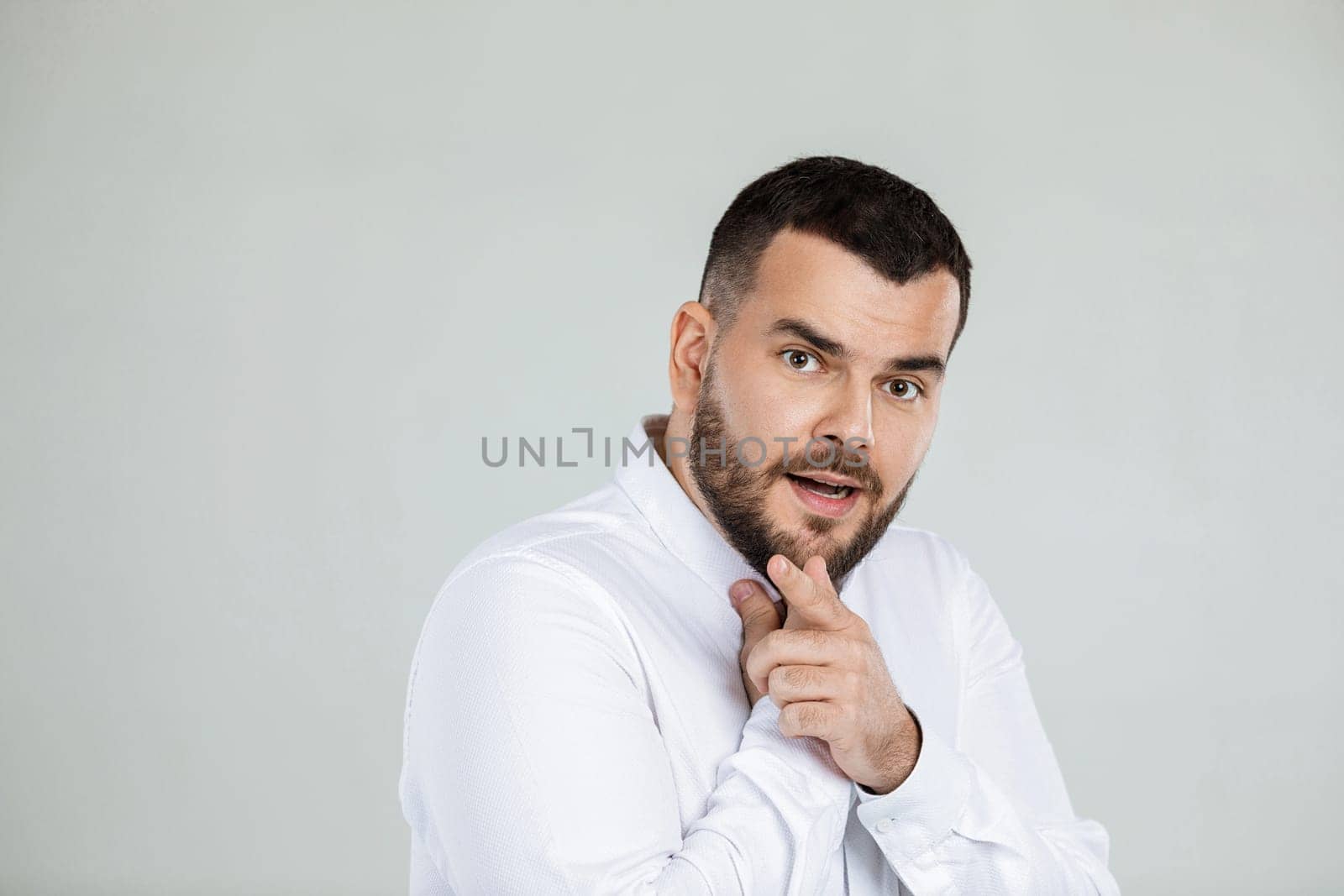 doubtful bearded man thinking about something on gray background.