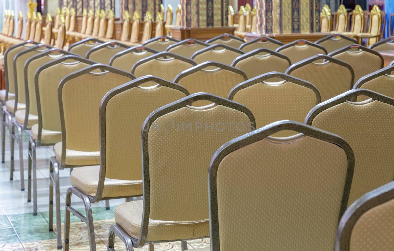 Bangkok, Thailand - May 22, 2024 - Perspective view of Metal chairs upholstered padded seat and Pulpit within Samphanthawong Saram Worawihan temple. Space for text, Selective focus.