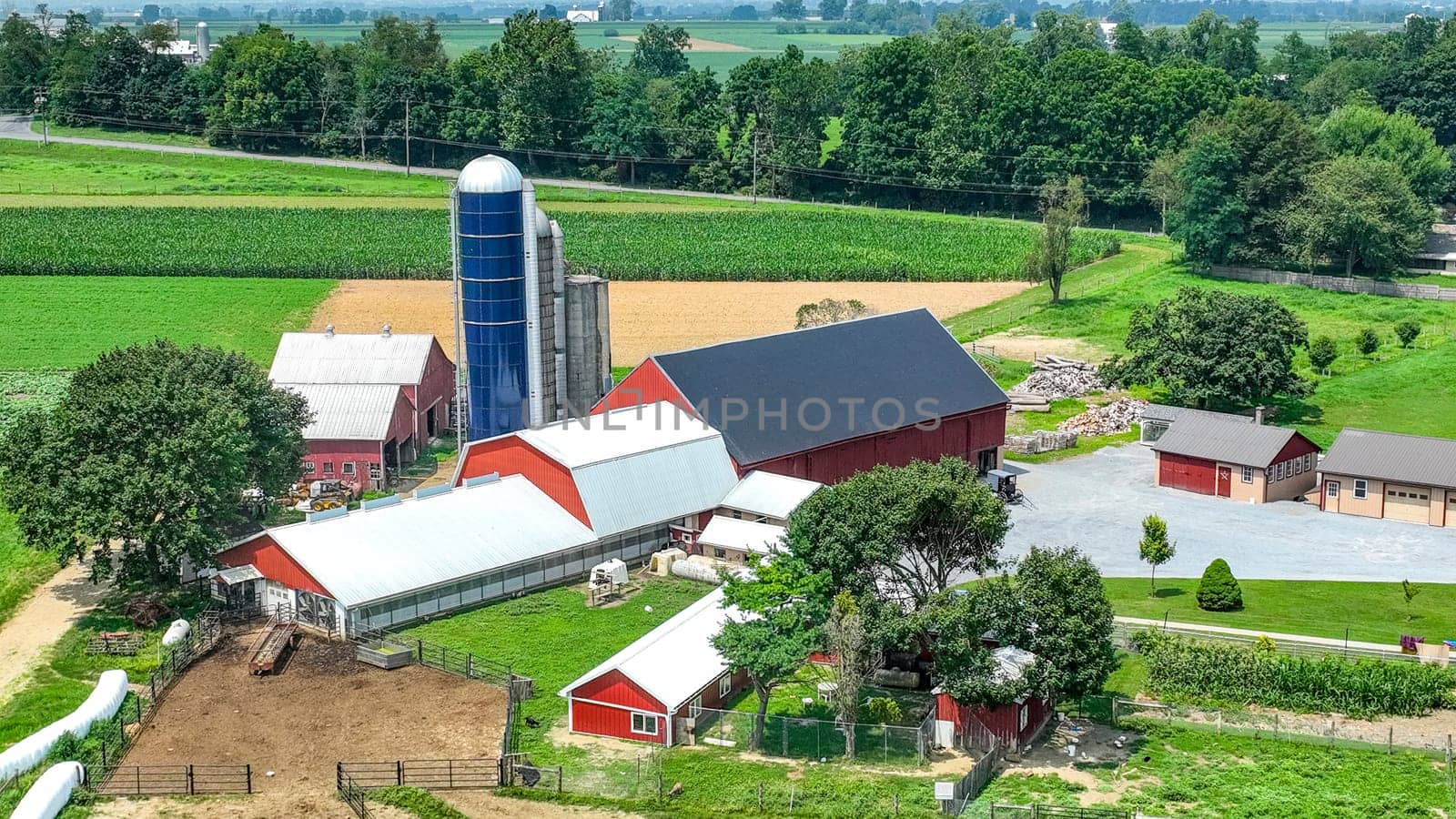 Paradise, Pennsylvania, USA, July 18. 2023 - An Aerial View of a Farmstead with Barns and Green Fields