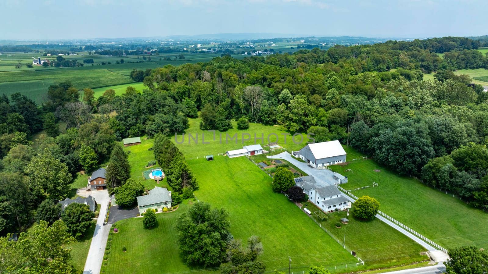 An aerial view of rural properties and farmland in the countryside, agriculture, green fields, landscape, drone photography, scenic, rural homes