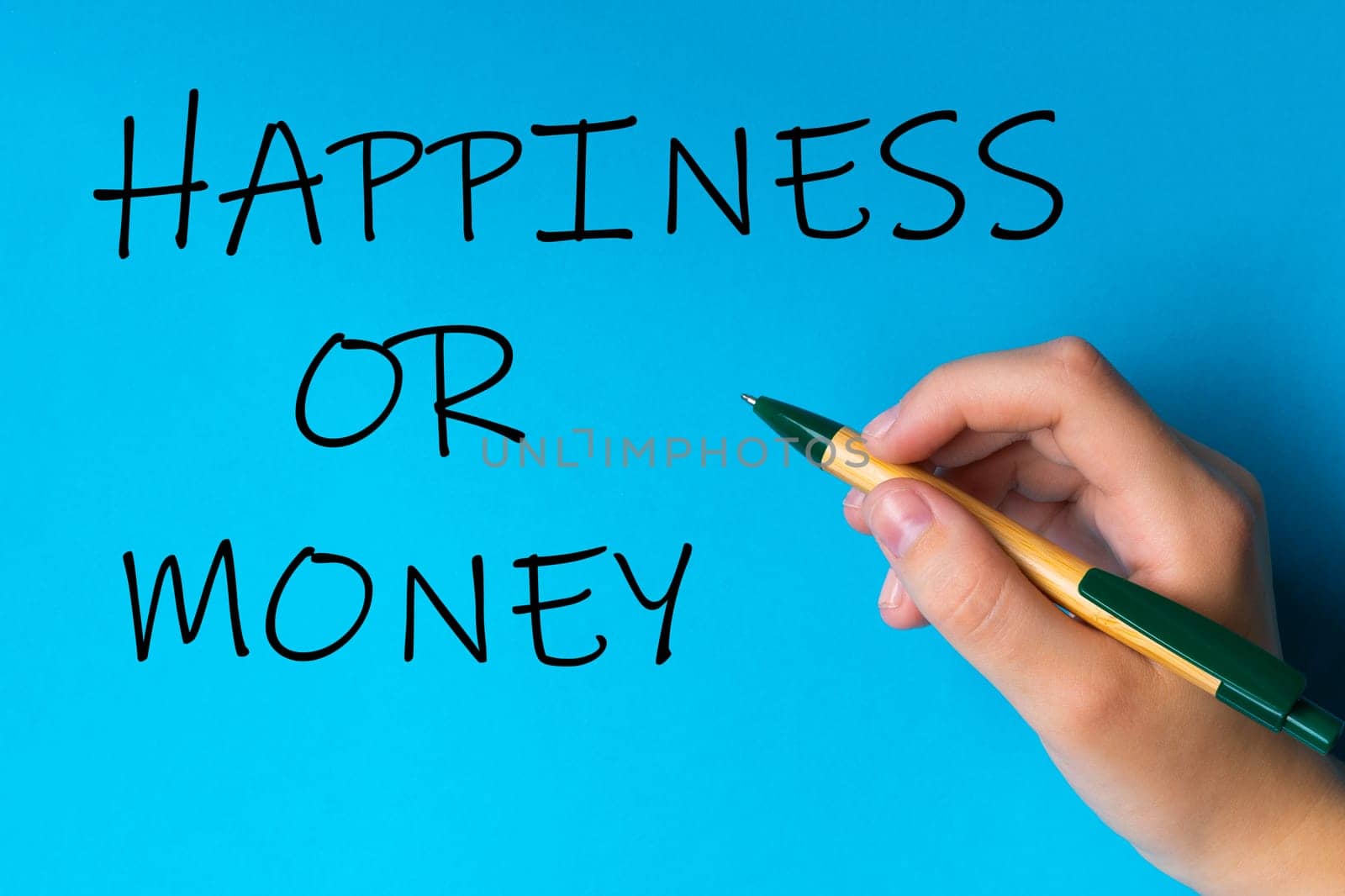 Children hand with pen write on a blue white background. Writing hand. Word Happiness or money