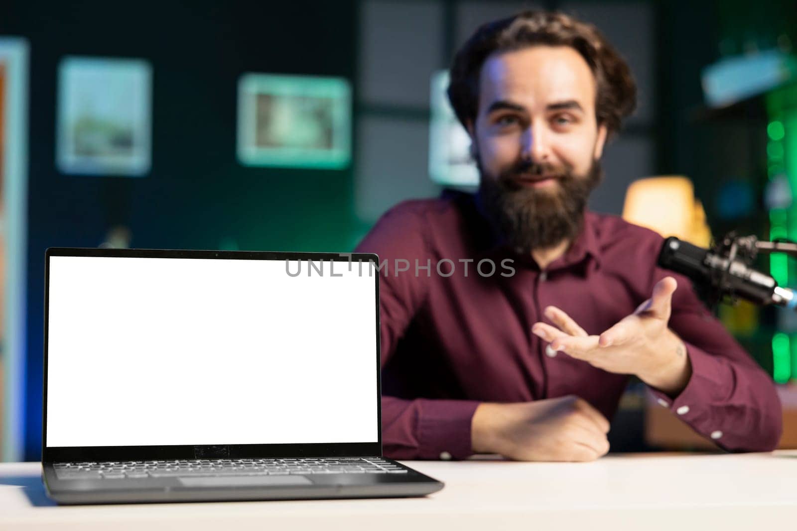 Close up shot of mockup laptop being assessed by cheerful tech expert talking about parts used inside. Focus on isolated screen notebook reviewed by man in blurry background for technology channel