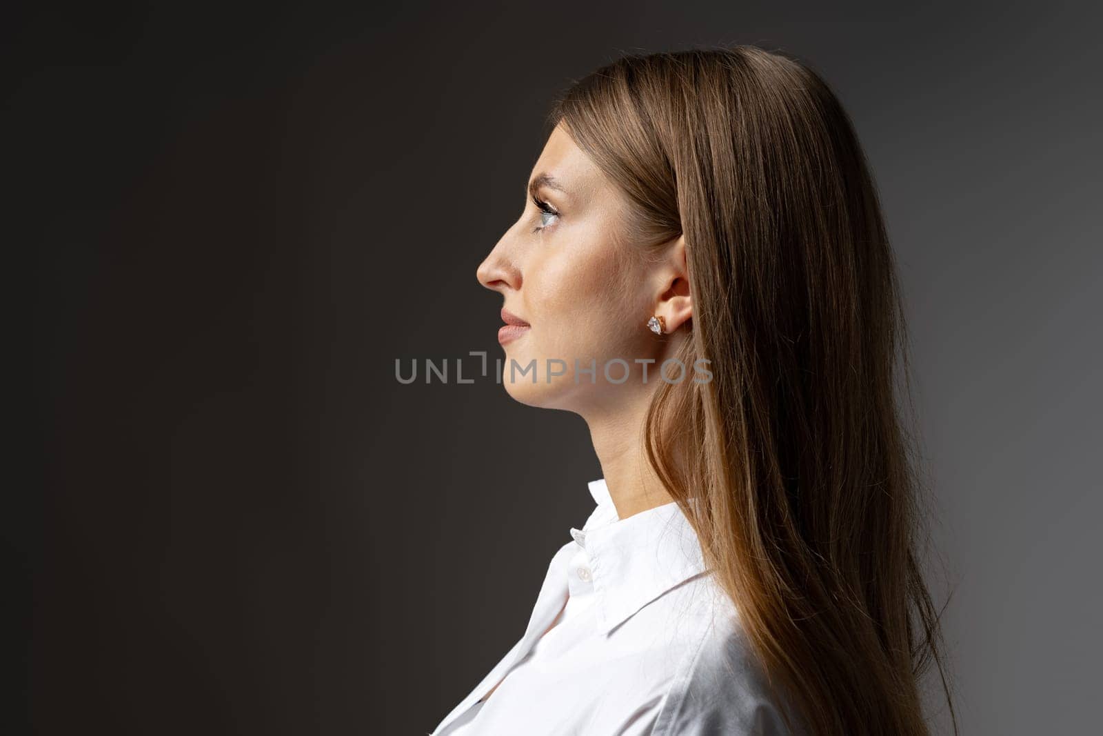 Thoughtful businesswoman portrait on a dark gray background close up