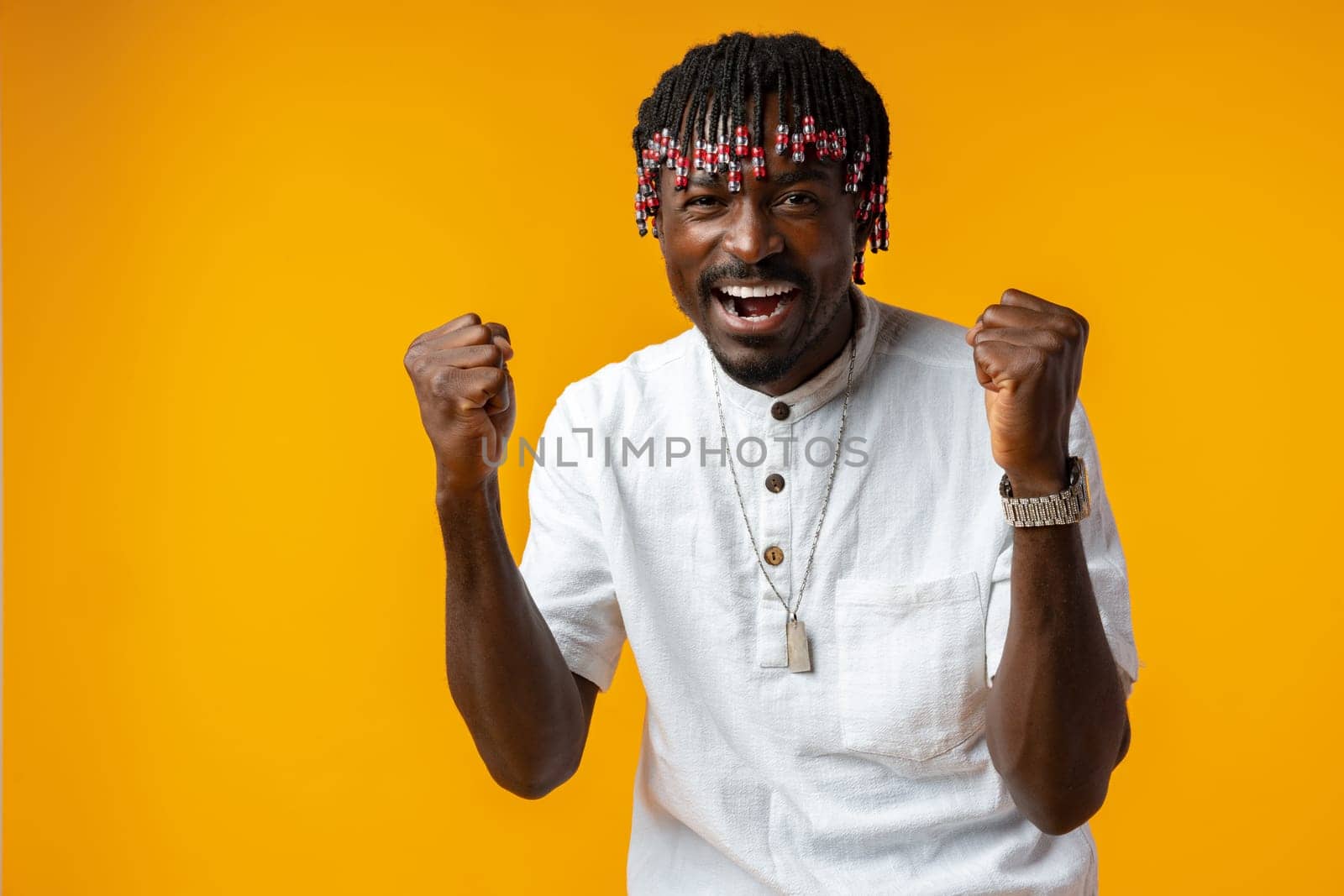 Young african man standing over yellow background doing winner gesture, close up