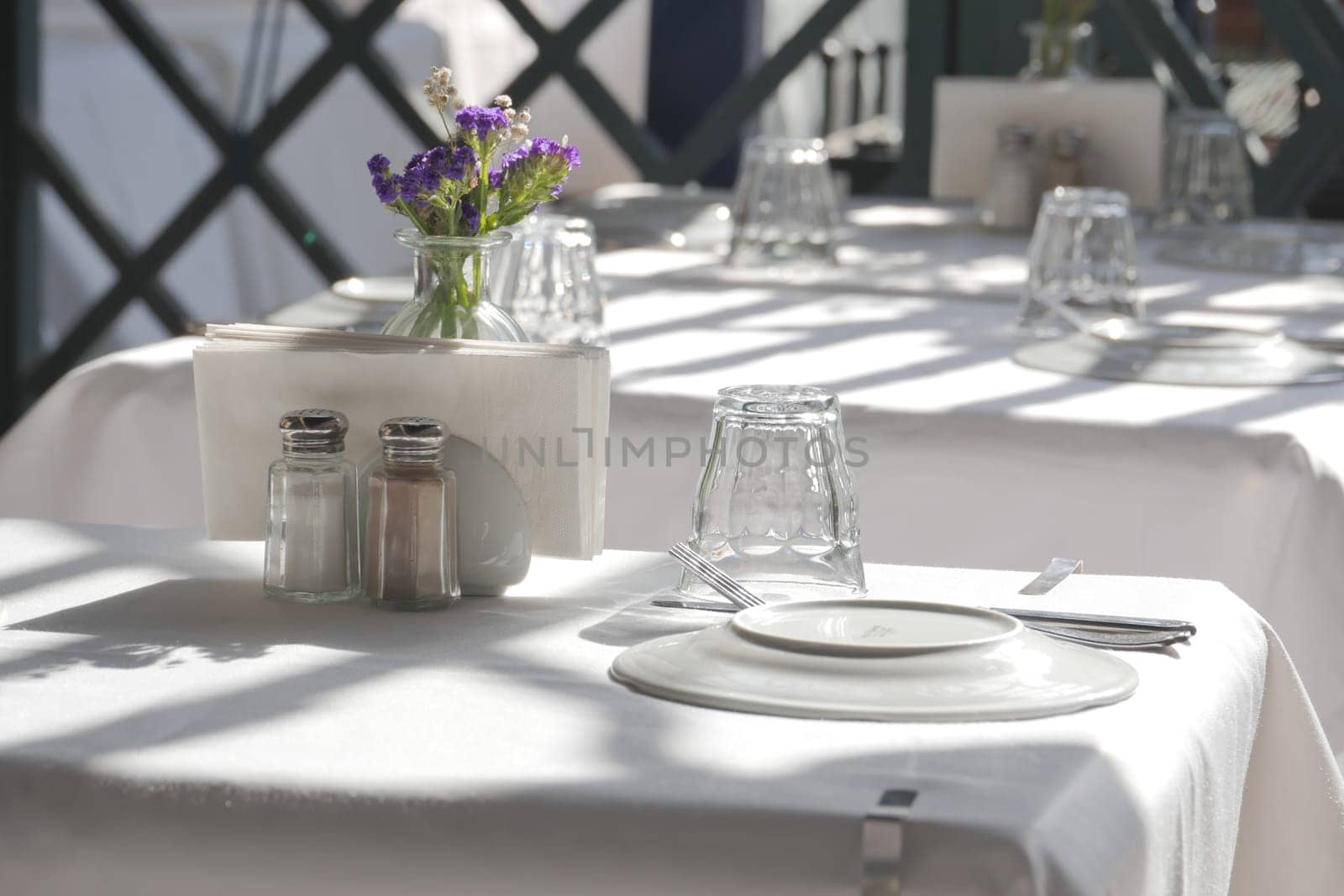 An elegant table with white tablecloth and a vase of flowers.