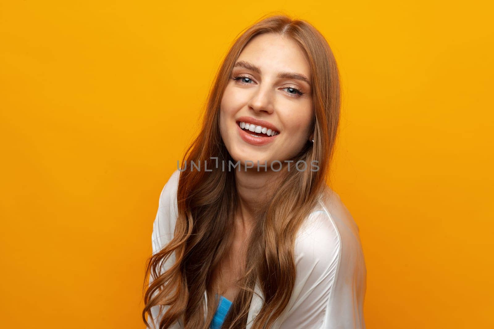 Pretty young woman smiling over yellow isolated background in studio