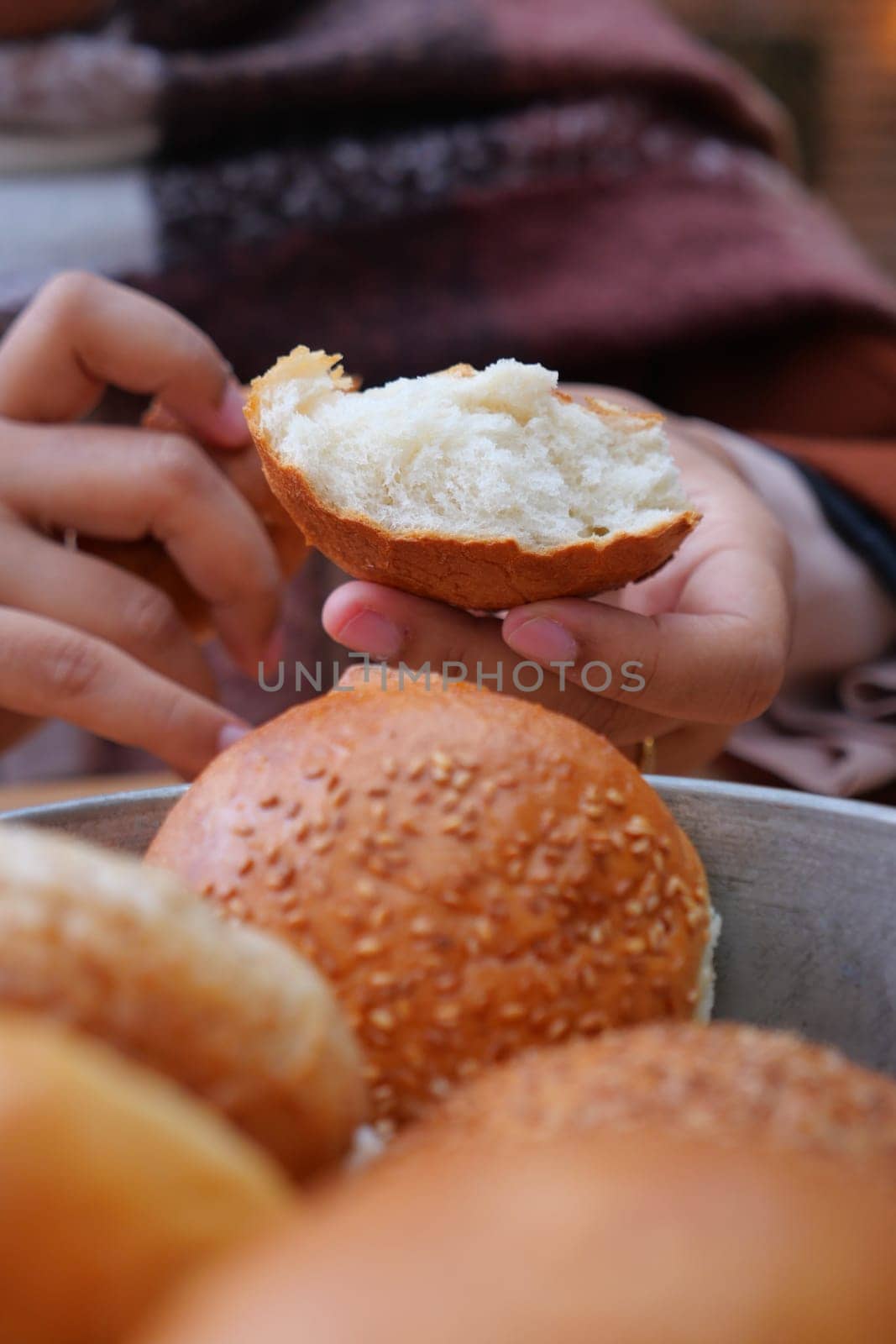 woman hand pick baked bun on table .