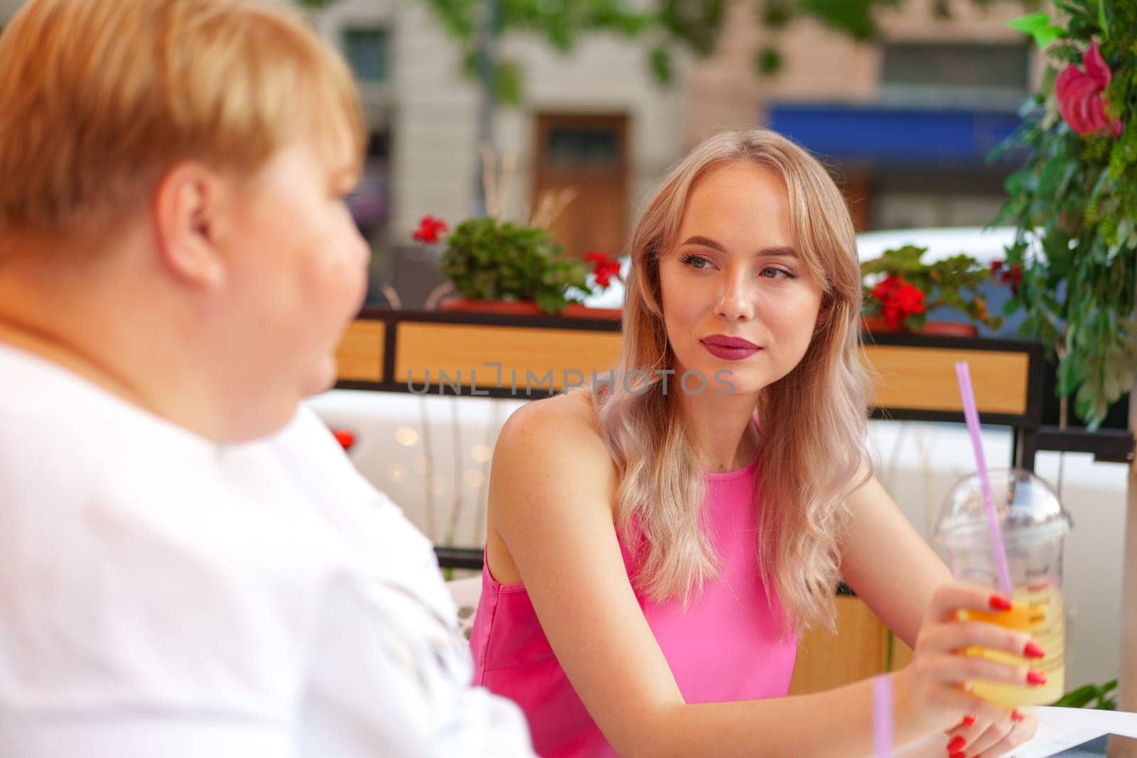 Portrait of two women, a mother and her daughter sitting in a outdoor cafe