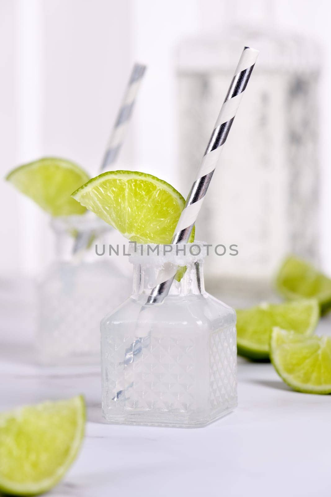 Classic alcoholic cocktail Margarita. Served in mini bottles with salt and lime. An original idea for a buffet event.