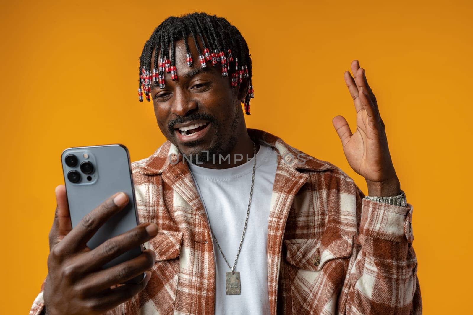 Young african man using smartphone over isolated yellow background close up