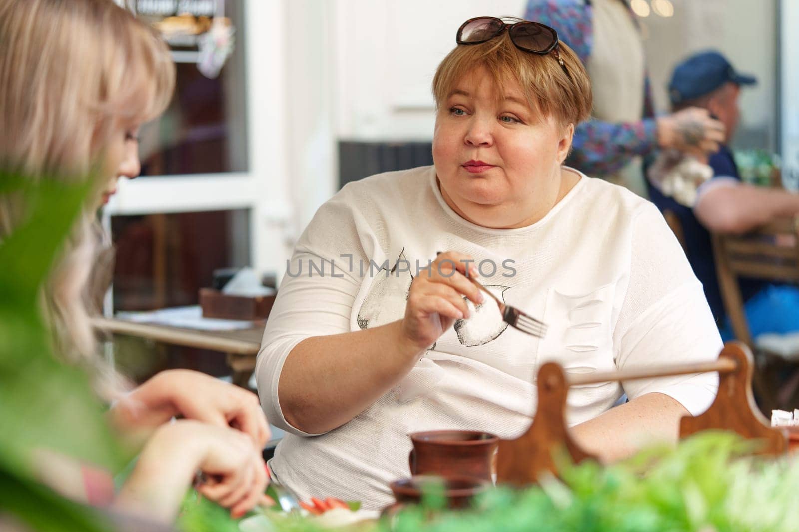 Portrait of two women, a mother and her daughter sitting in a outdoor cafe