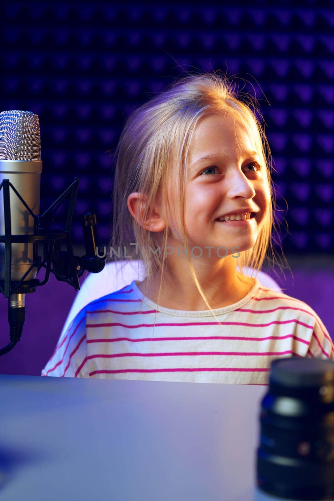 Smiling child girl sitting in recording studio portrait close up