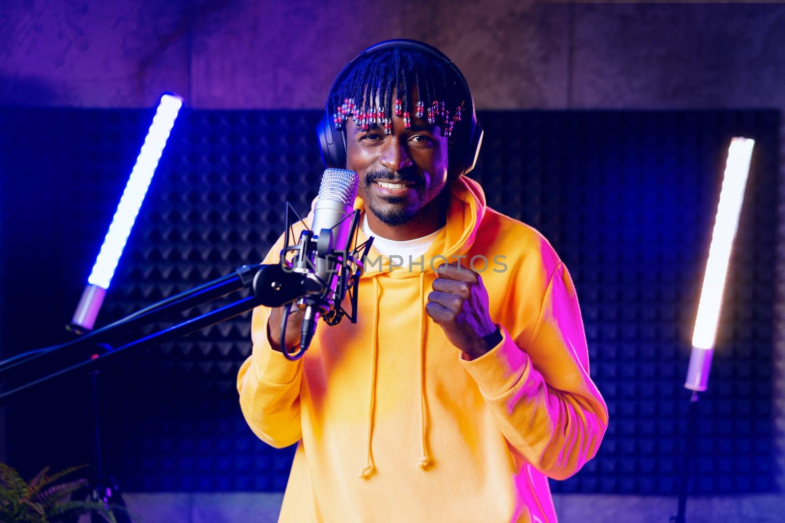 Young African performer recording his new track in recording studio, close up portrait