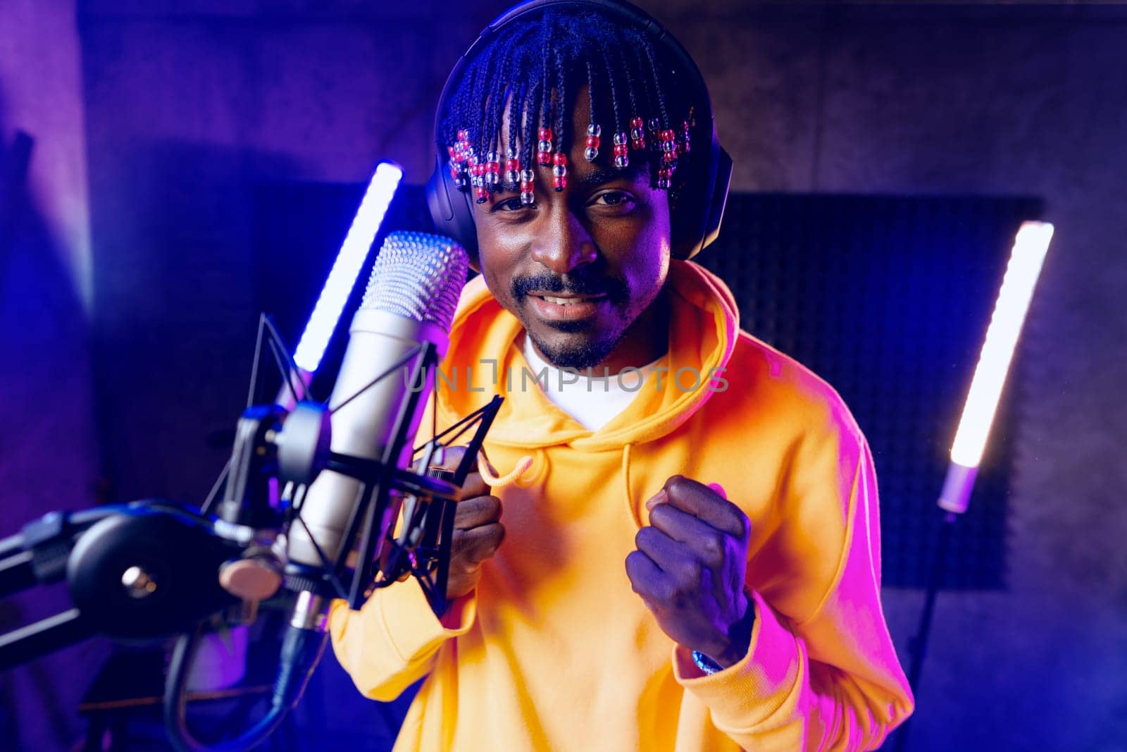 Young African performer recording his new track in recording studio, close up portrait