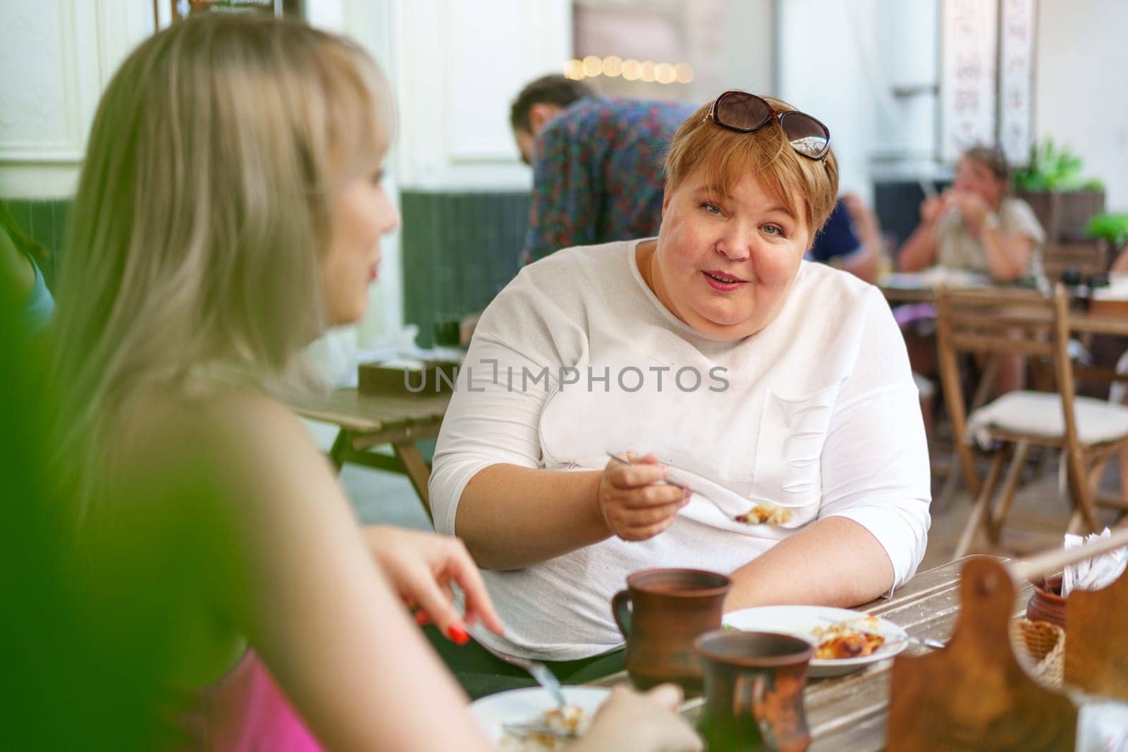 Portrait of two women, a mother and her daughter sitting in a outdoor cafe