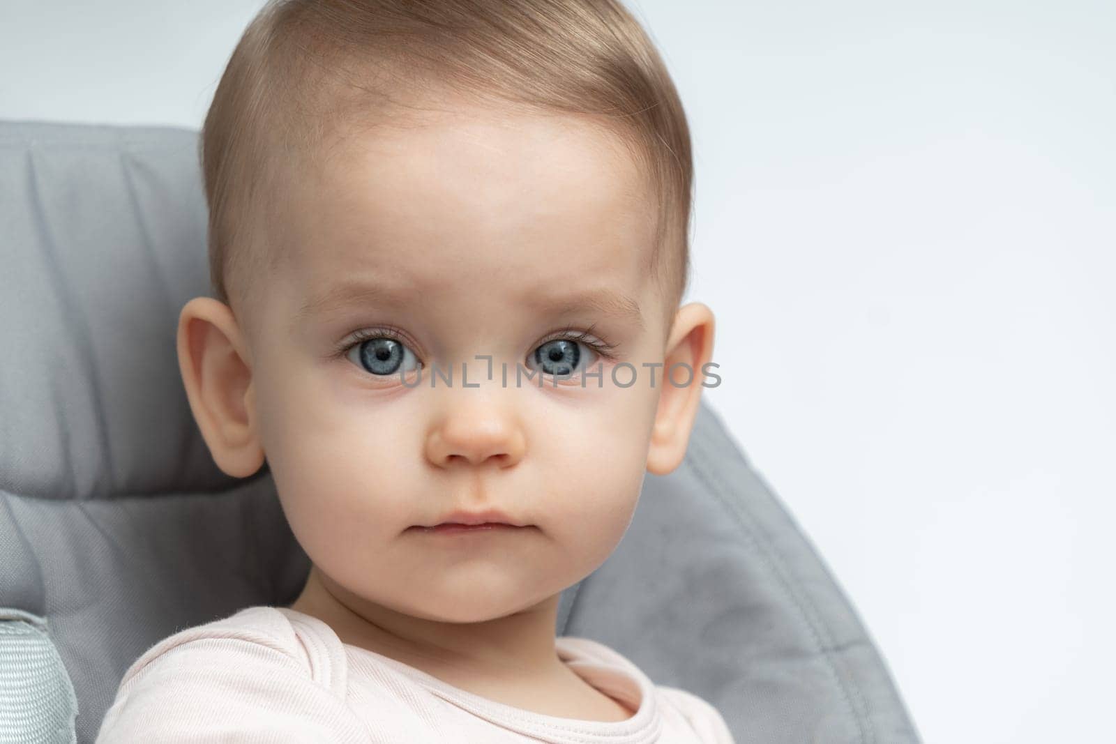 Close-up of an infant baby gazing at the camera with wide-eyed wonder