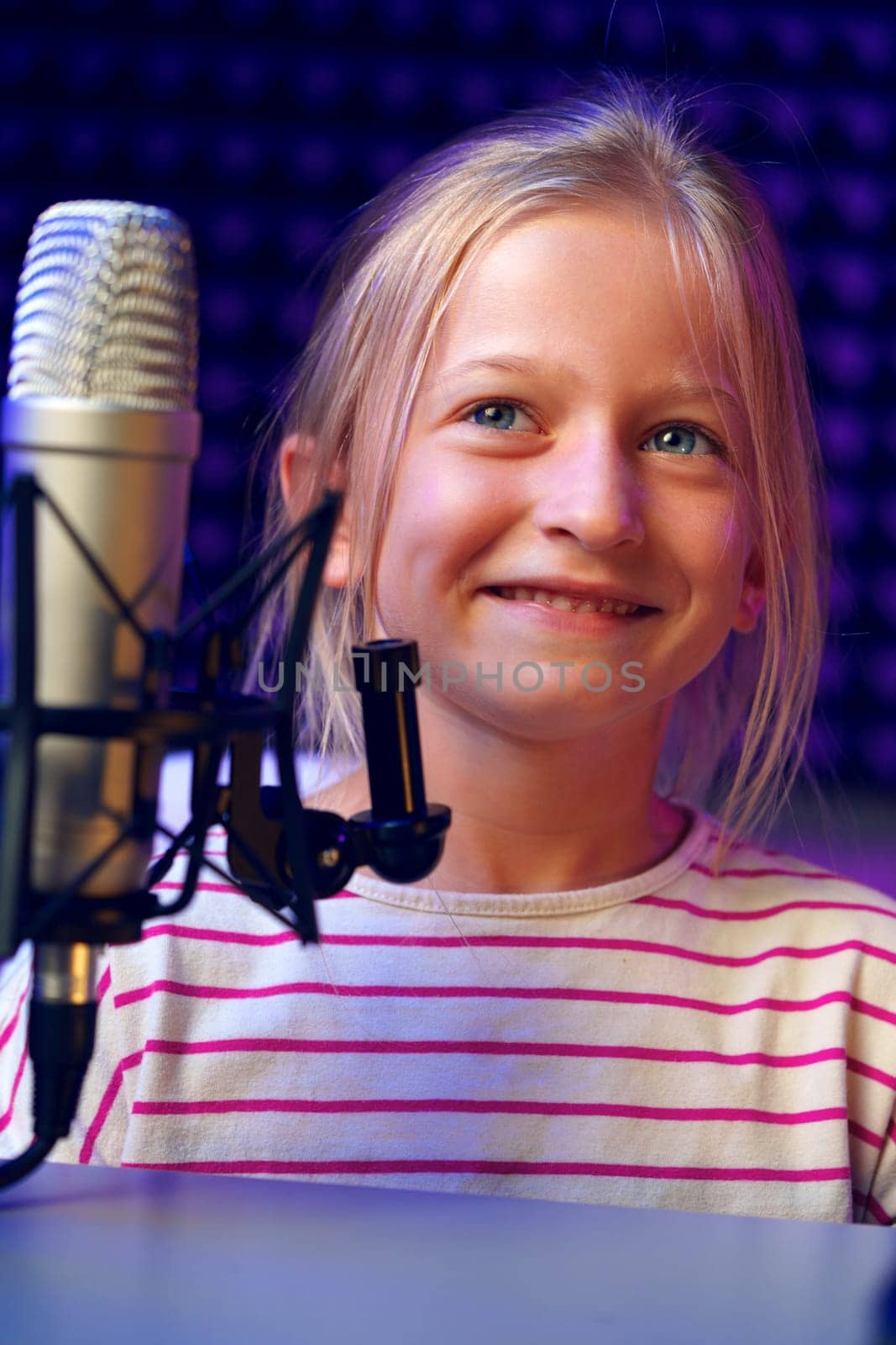 Smiling child girl sitting in recording studio portrait close up