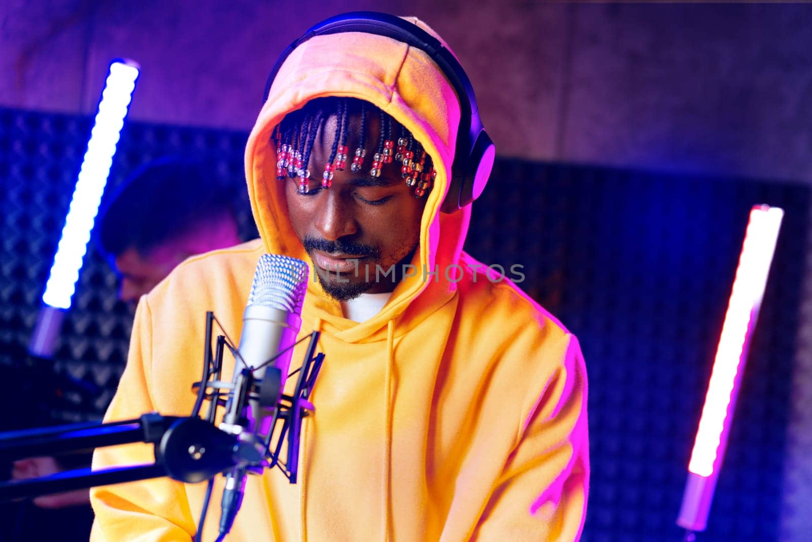 Young African performer recording his new track in recording studio, close up portrait