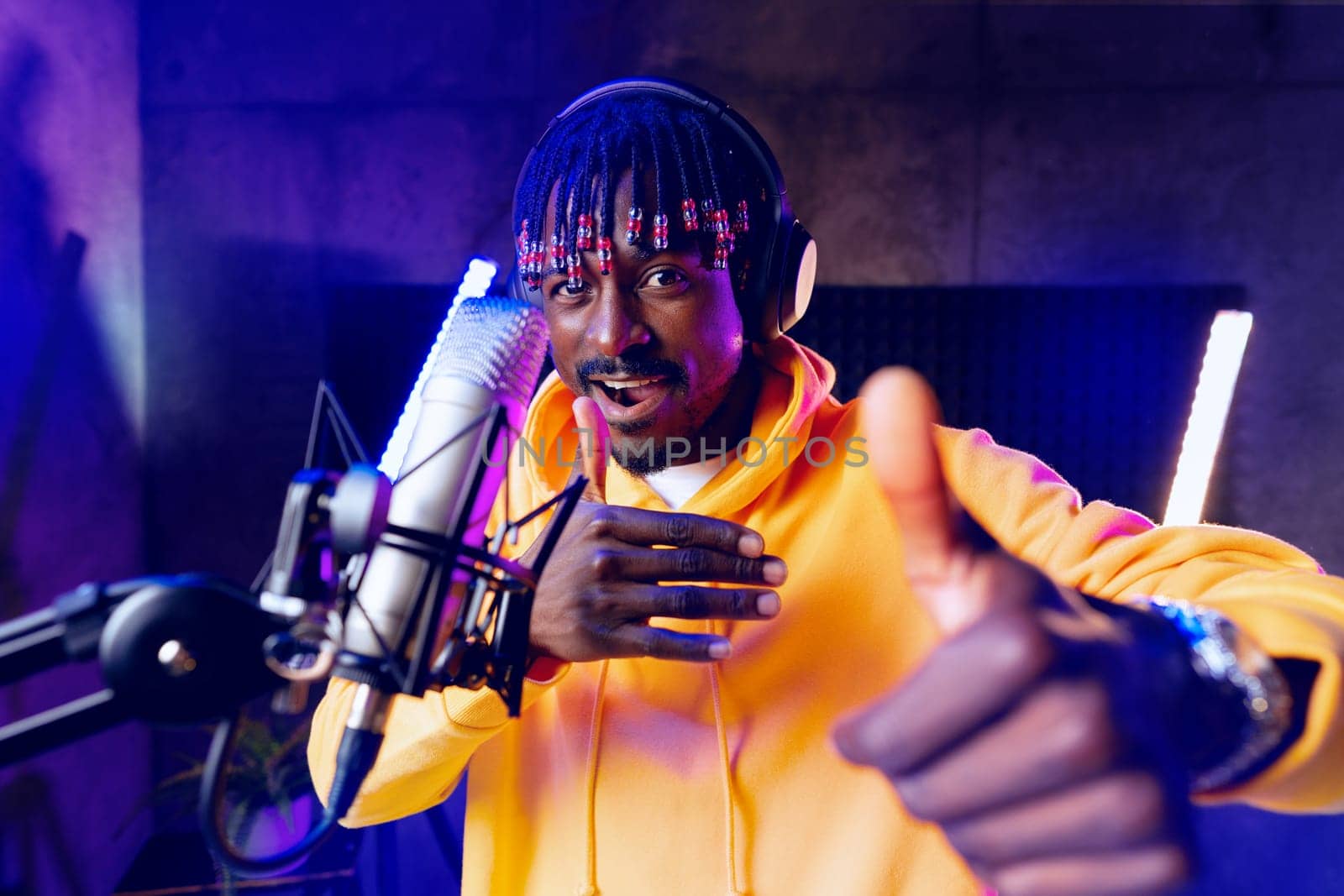 Young African performer recording his new track in recording studio, close up portrait