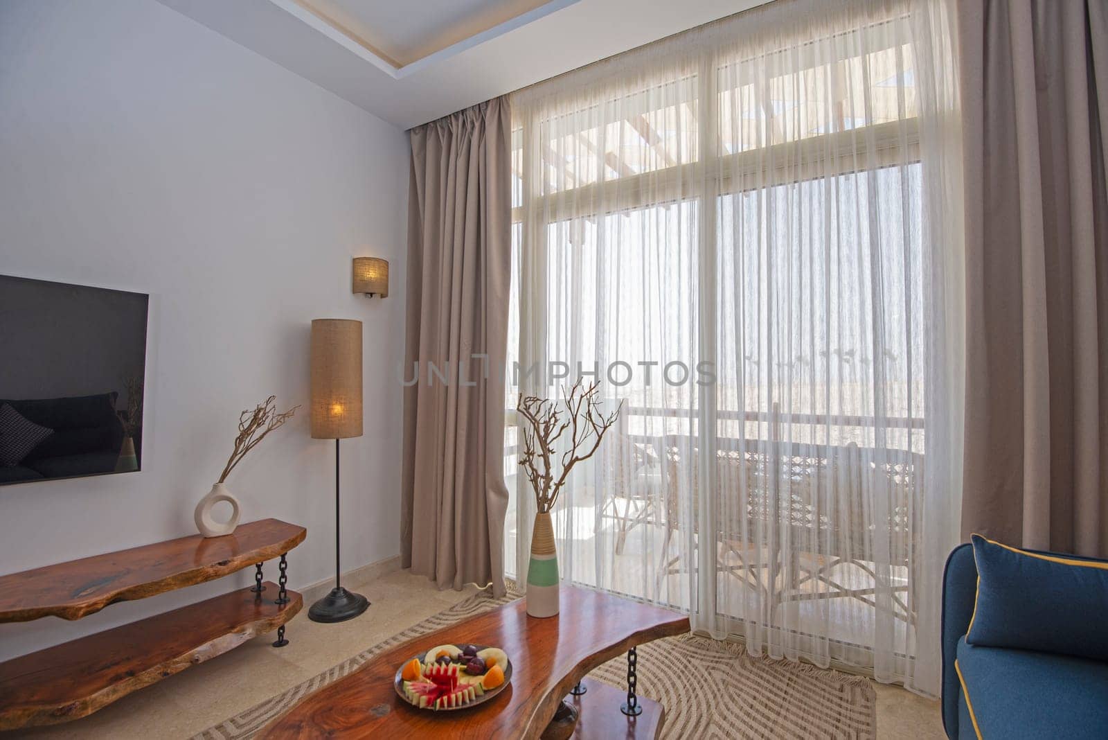 Living room lounge area in luxury apartment show home showing interior design decor furnishing with balcony terrace