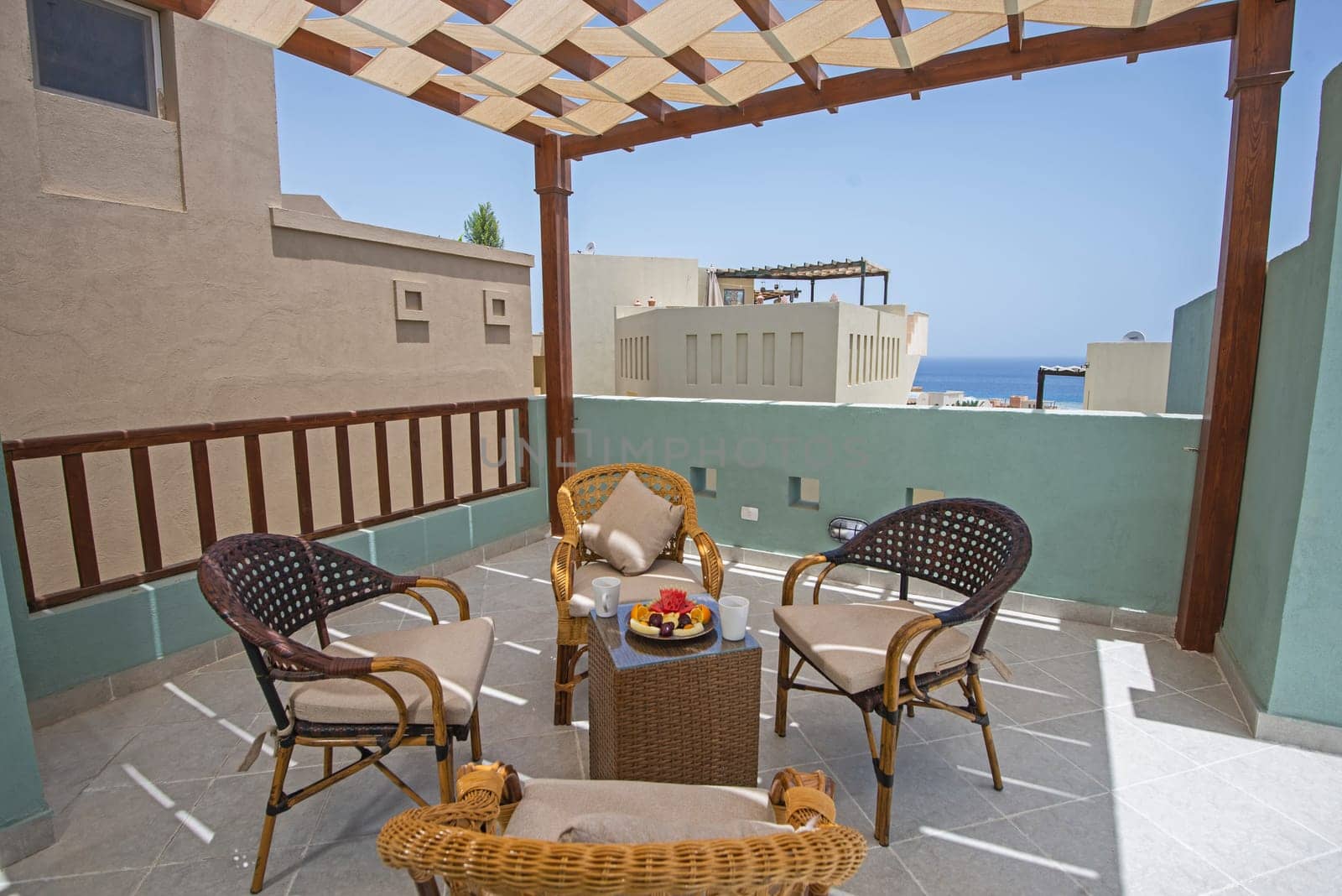Roof terrace of a luxury apartment in tropical resort with furniture and sea view from balcony