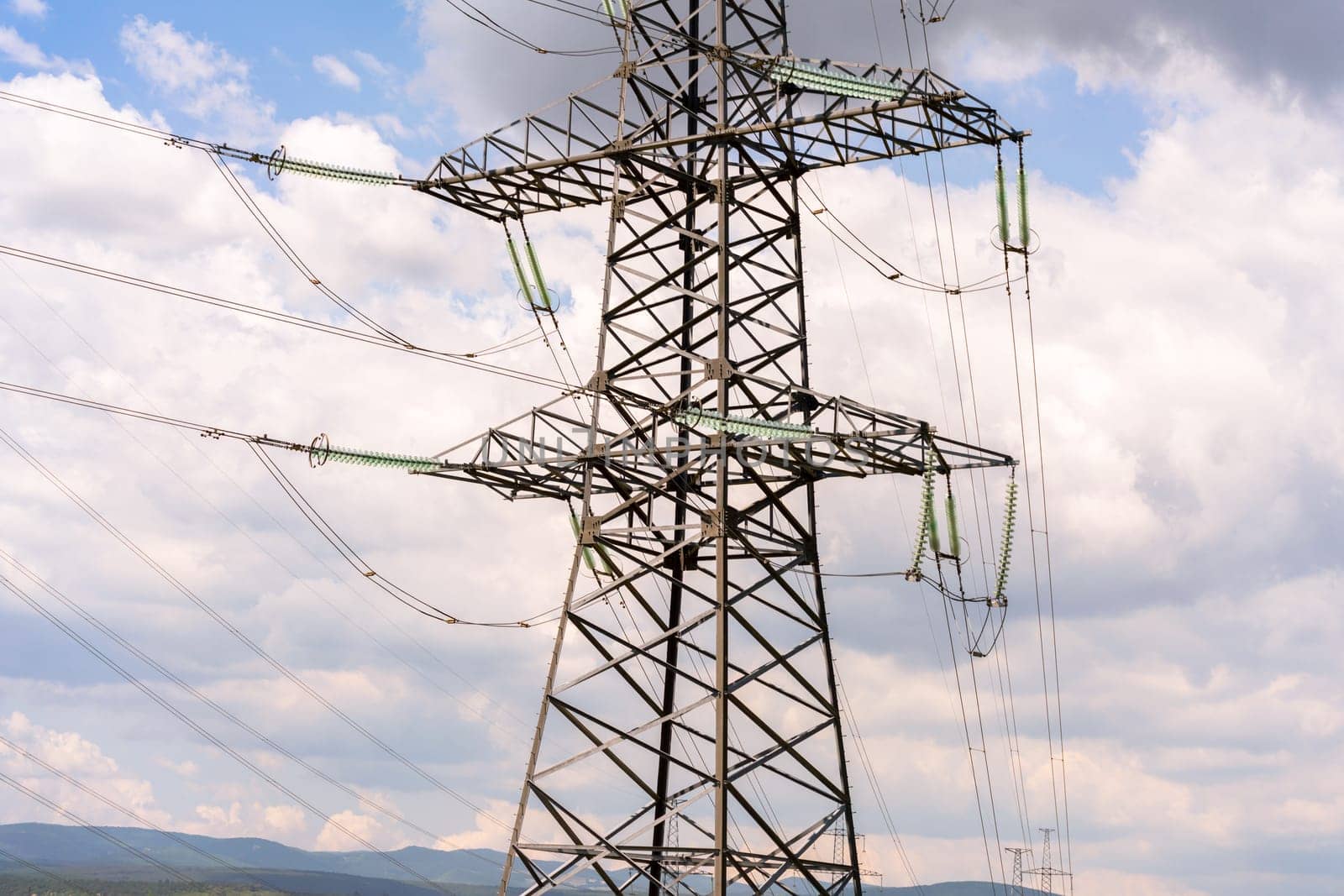 High voltage towers with sky background. Power line support with wires for electricity transmission. High voltage grid tower with wire cable at distribution station. Energy industry, energy saving.