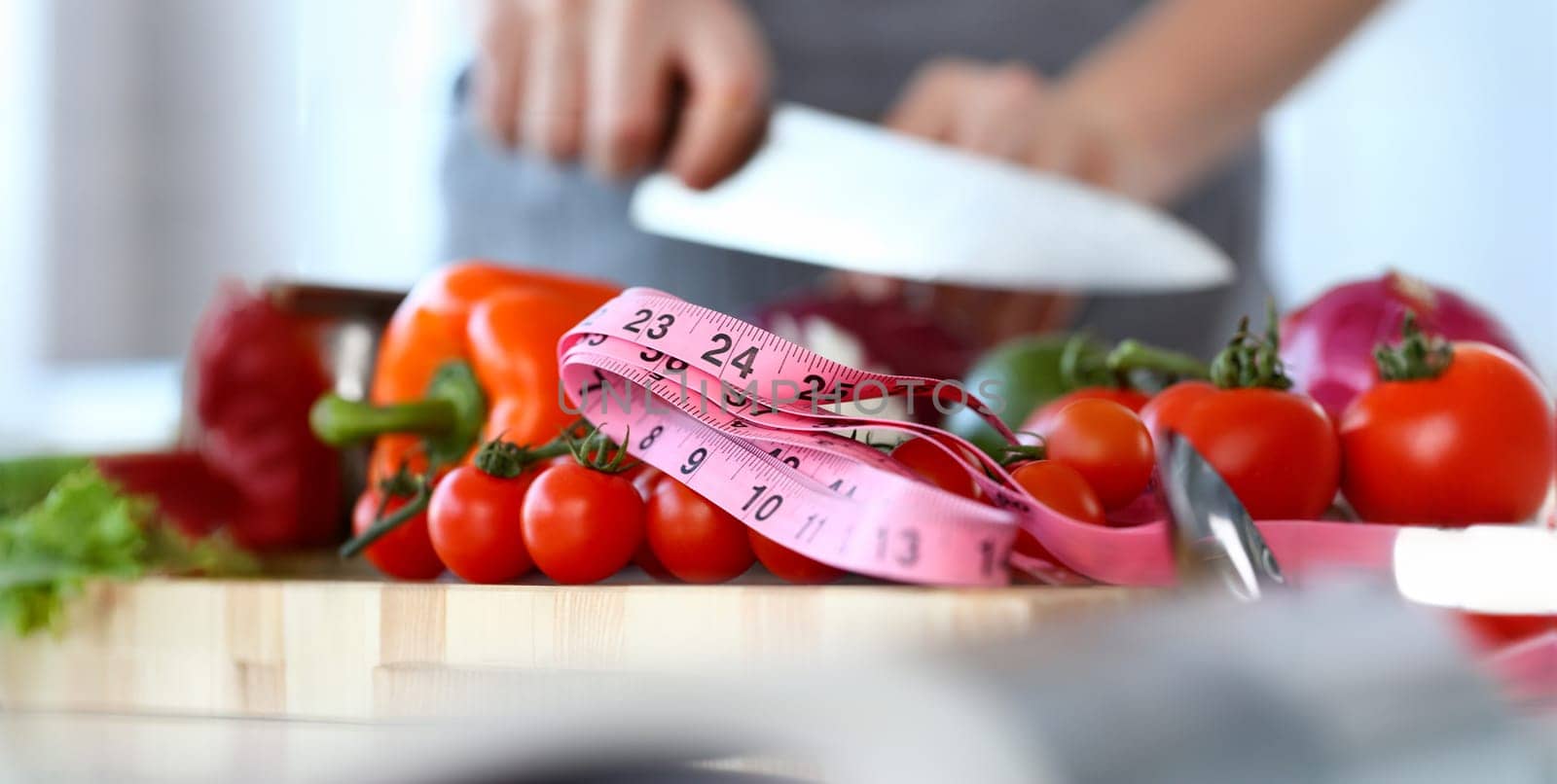 Organic Small Cherry Tomatoes Size Measurement. Fresh and Ripe Vegetables. Measuring of Culinary Ingredient with Pink Centimeter. Cooking with Sharp Knife Partial View Horizontal Photography