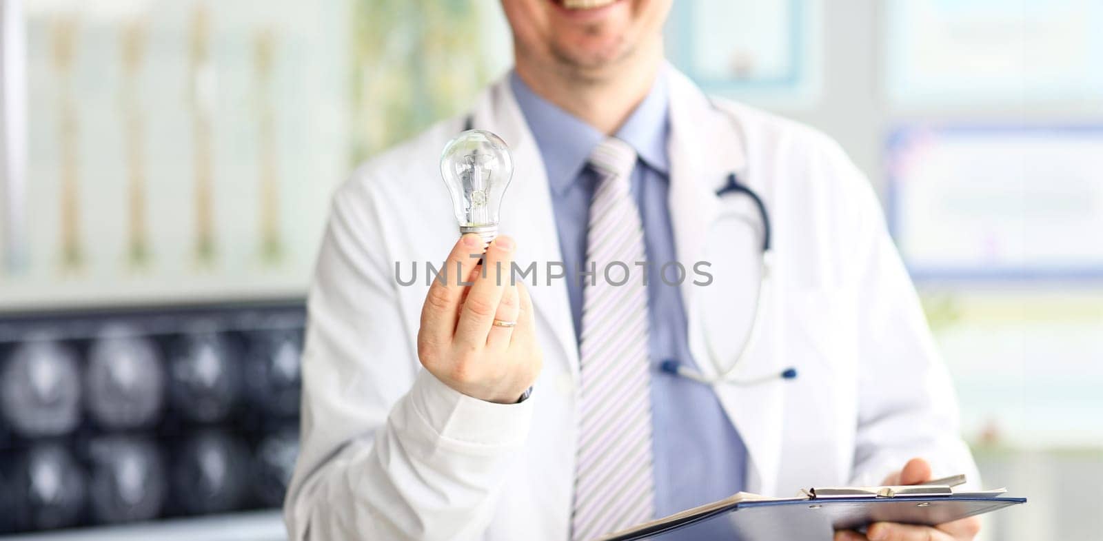Male doctor hand holding lightbulb as bright idea invention symbol closeup