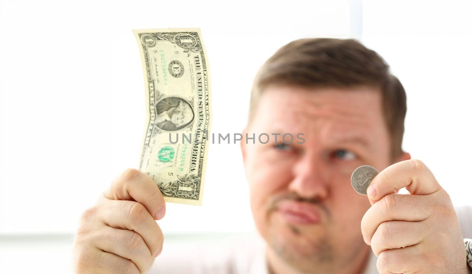 Arms of thoughtful man holding paper and coin currency trying to invent some good solution closeup